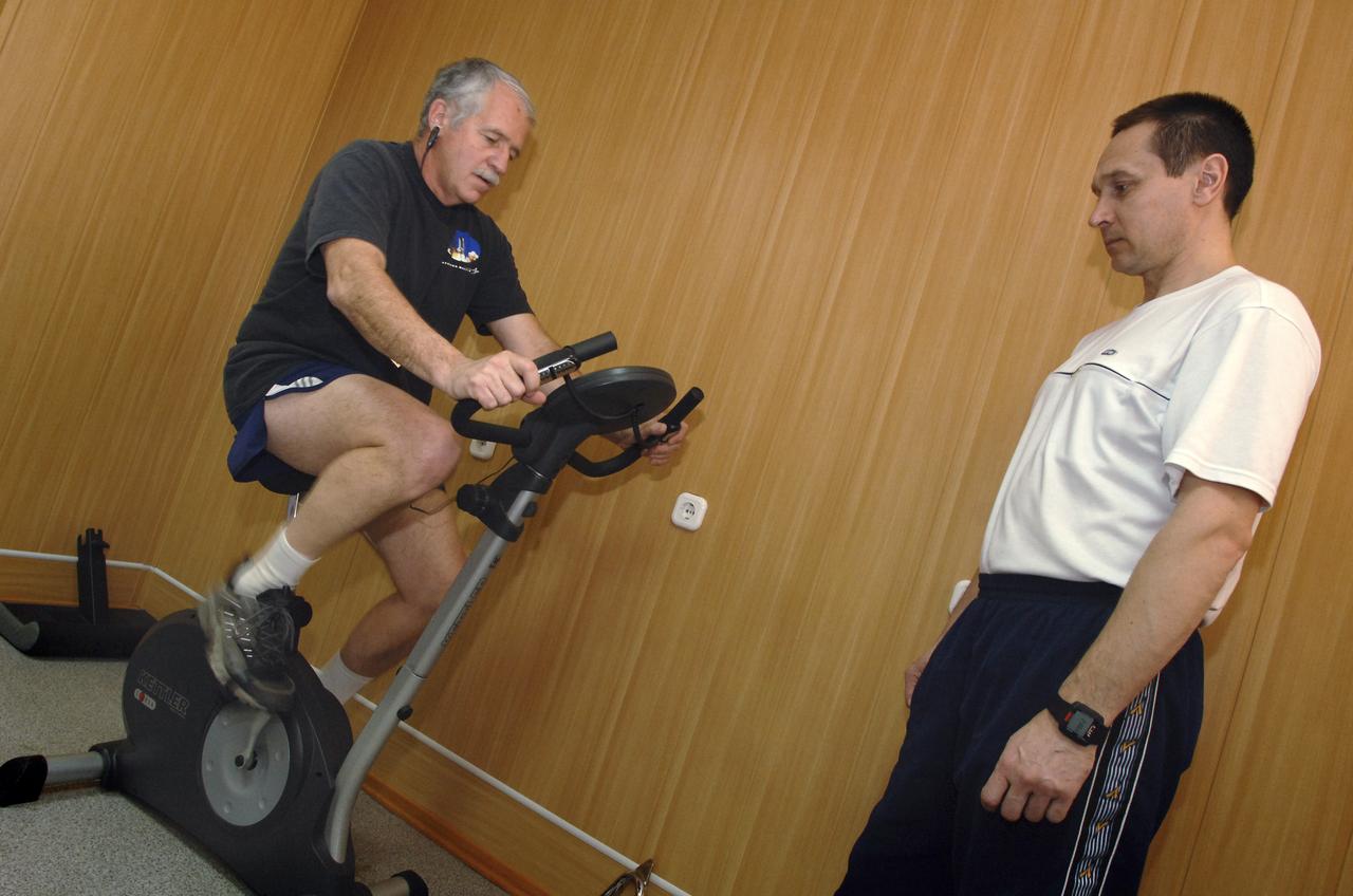 Expedition 11 Flight Engineer John Phillips, left, stays limber during an exercise session, Sunday, April 10, 2005, in Baikonur, Kazakhstan as he prepares for the April 15 launch to the International Space Station. Photo Credit: (NASA/Bill Ingalls)