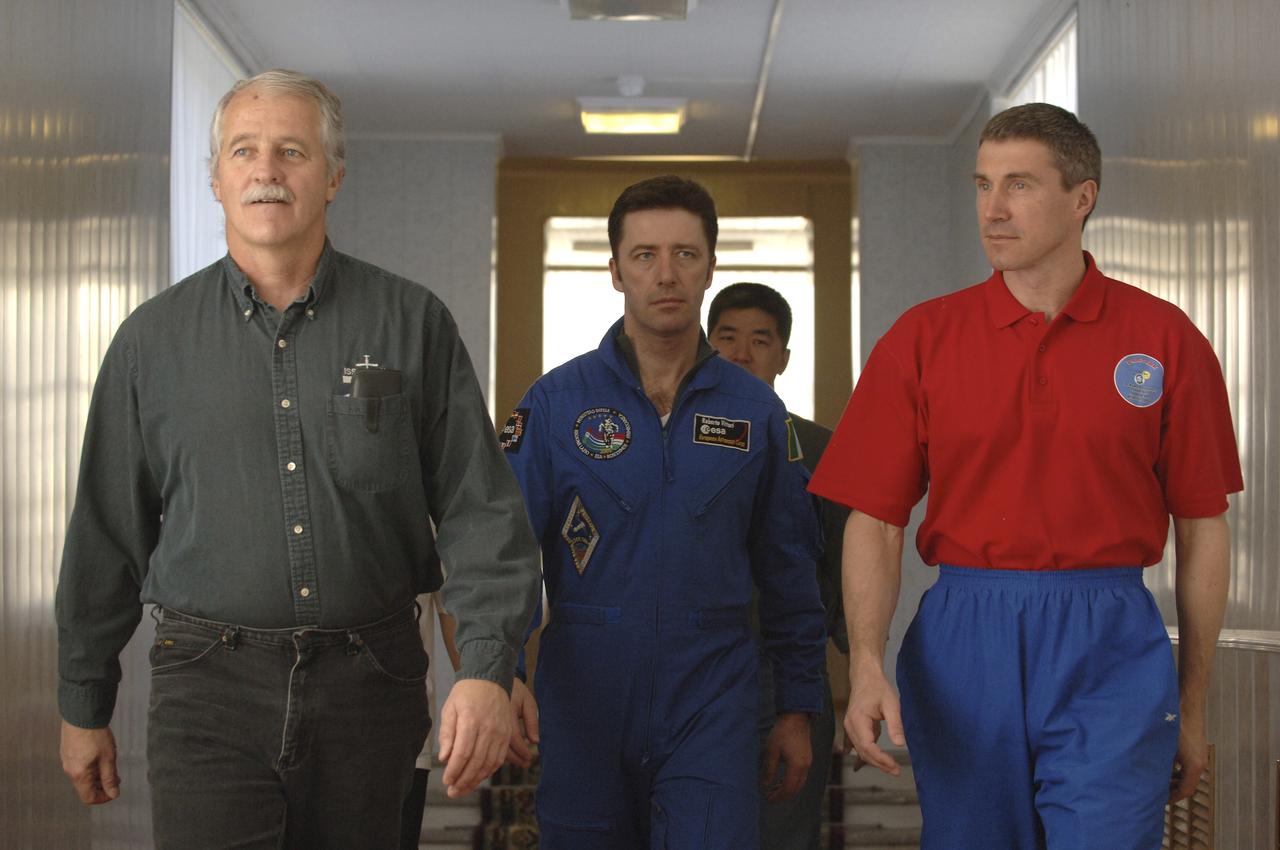 Expedition 11 Flight Engineer John Phillips, left, European Space Agency Astronaut Roberto Vittori, of Italy and Commander Sergei Krikalev, right, walk in the Cosmonaut hotel in Baikonur, Kazakhstan, Monday, April 11, 2005. The trio will launch April 15 aboard a Soyuz TMA-6 spacecraft to the International Space Station. Krikalev and Phillips will spend six months in space and greet the first Shuttle crew to fly in more than two years when it arrives at the station, while Vittori will spend eight days on the station under a commercial contract between ESA and the Russian Federal Space Agency. Photo Credit: (NASA/Bill Ingalls)