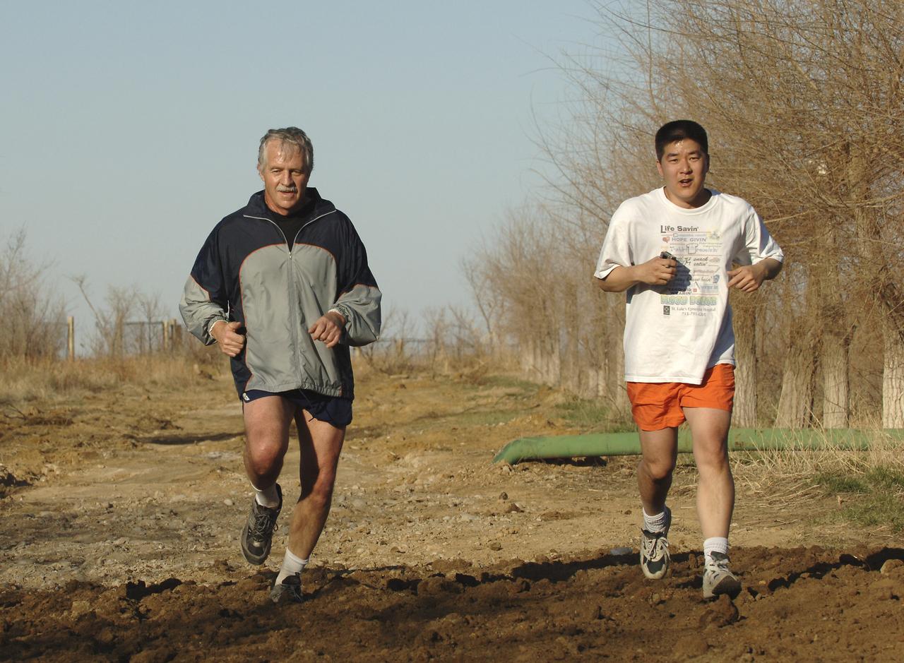 Expedition 11 Flight Engineer John Phillips, left, and backup American Dan Tani stay limber during an exercise session, Monday, April 11, 2005, in Baikonur, Kazakhstan as Philips prepares for the April 15 launch to the International Space Station with Expedition 11 Commander Sergei Krikalev and European Space Agency Astronaut Roberto Vittori, of Italy. Krikalev and Phillips will spend six months in space and greet the first Shuttle crew to fly in more than two years when arrive at the station, while Vittori spends eight days on the station under a commercial contract between ESA and the Russian Federal Space Agency. Photo Credit: (NASA/Bill Ingalls)