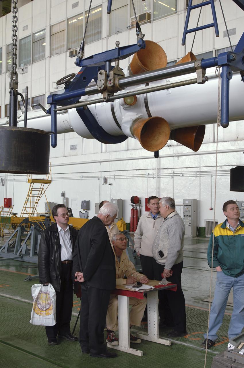 Russian technicians work, Tuesday, April 12, 2005, on mating the Soyuz TMA-6 spacecraft to the booster rocket inside the integration facility at the Baikonur Cosmodrome in Kazakhstan as preparations continued for the April 15 launch of Expedition 11 with Commander Sergei Krikalev, Flight Engineer John Phillips and European Space Agency Astronaut Roberto Vittori, of Italy, to the International Space Station. The rocket mating operation occurred on the 44th anniversary of the launch of Yuri Gagarin from the same complex to become the first human in space. Photo Credit: (NASA/Bill Ingalls)