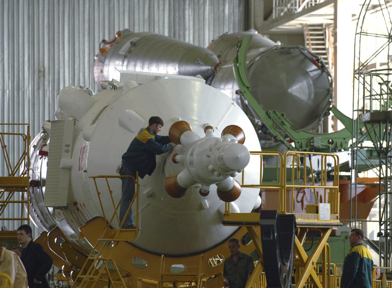 Russian technicians work, Tuesday, April 12, 2005, on mating the Soyuz TMA-6 spacecraft to the booster rocket inside the integration facility at the Baikonur Cosmodrome in Kazakhstan as preparations continued for the April 15 launch of Expedition 11 with Commander Sergei Krikalev, Flight Engineer John Phillips and European Space Agency Astronaut Roberto Vittori, of Italy, to the International Space Station. The rocket mating operation occurred on the 44th anniversary of the launch of Yuri Gagarin from the same complex to become the first human in space. Photo Credit: (NASA/Bill Ingalls)