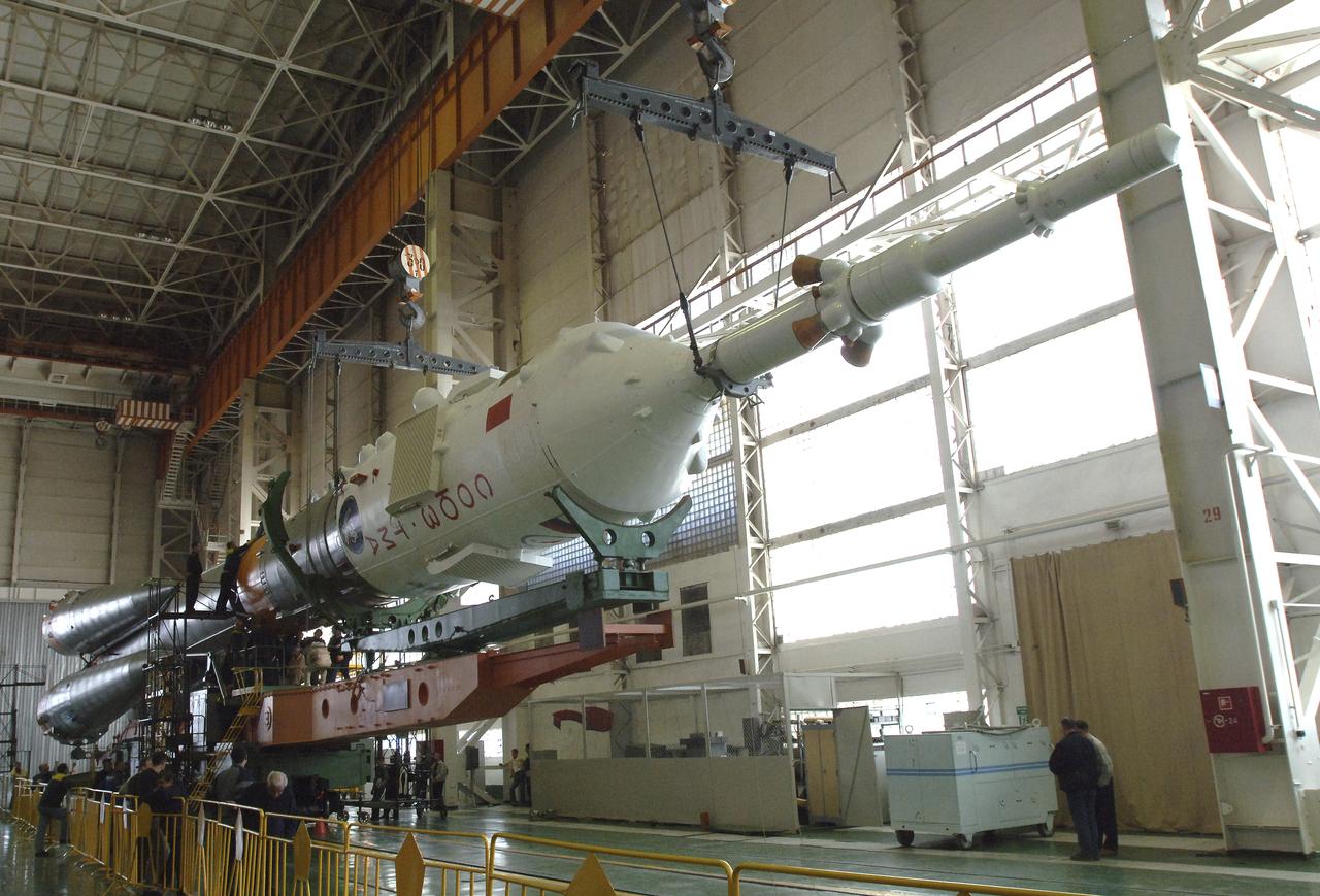 Russian technicians work, Tuesday, April 12, 2005, on mating the Soyuz TMA-6 spacecraft to the booster rocket inside the integration facility at the Baikonur Cosmodrome in Kazakhstan as preparations continued for the April 15 launch of Expedition 11 with Commander Sergei Krikalev, Flight Engineer John Phillips and European Space Agency Astronaut Roberto Vittori, of Italy, to the International Space Station. The rocket mating operation occurred on the 44th anniversary of the launch of Yuri Gagarin from the same complex to become the first human in space. Photo Credit: (NASA/Bill Ingalls)