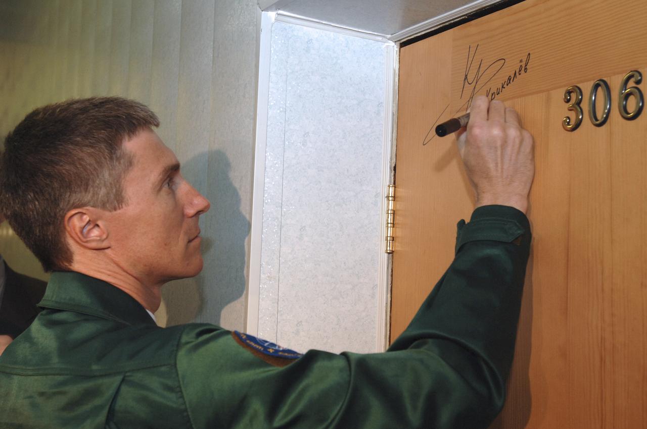 Expedition 11 Commander Sergei Krikalev autographs the door to his cosmonaut hotel room, part of a pre-launch tradition, prior to the launch aboard the Soyuz TMA-6 spacecraft, Thursday, April 14, 2005, in Baikonur, Kazakhstan. Photo Credit: (NASA/Bill Ingalls)