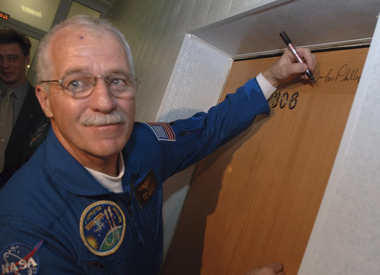 Expedition 11 Flight Engineer and NASA Science Officer John Phillips autographs the door to his Cosmonaut Hotel room, part of a pre-launch tradition, prior to the launch aboard the Soyuz TMA-6 spacecraft, Thursday, April 14, 2005, in Baikonur, Kazakhstan. Photo Credit: (NASA/Bill Ingalls)
