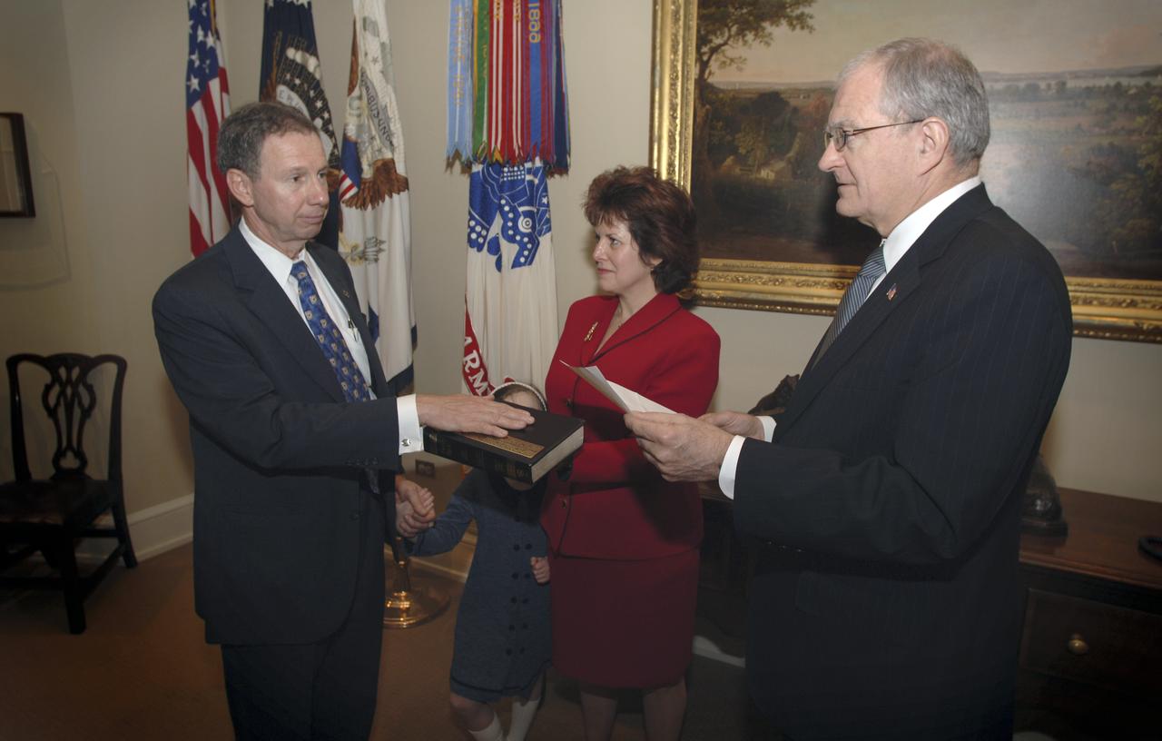 NASA Administrator Michael Griffin, left, is administered the oath of office by John H. Marburger, right, Science Adviser to the President and Office of Science and Technology Policy Director, during a private ceremony at the Old Executive Office Building, Thursday, April 14, 2005, in Washington, while his wife Rebecca and daughter Katie look on. Photo Credit: (NASA/Renee Bouchard)