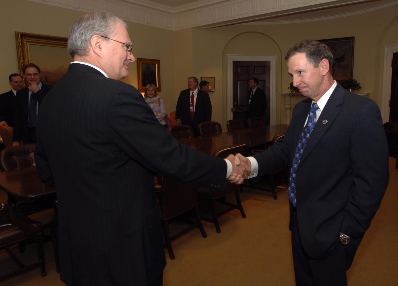 John H. Marburger, Science Adviser to the President and Director of the Office of Science and Technology Policy (OSTP), left, shakes hands with NASA Administrator Michael Griffin following his swearing-in, Thursday, April 14, 2005, in Washington. Photo Credit: (NASA/Renee Bouchard)