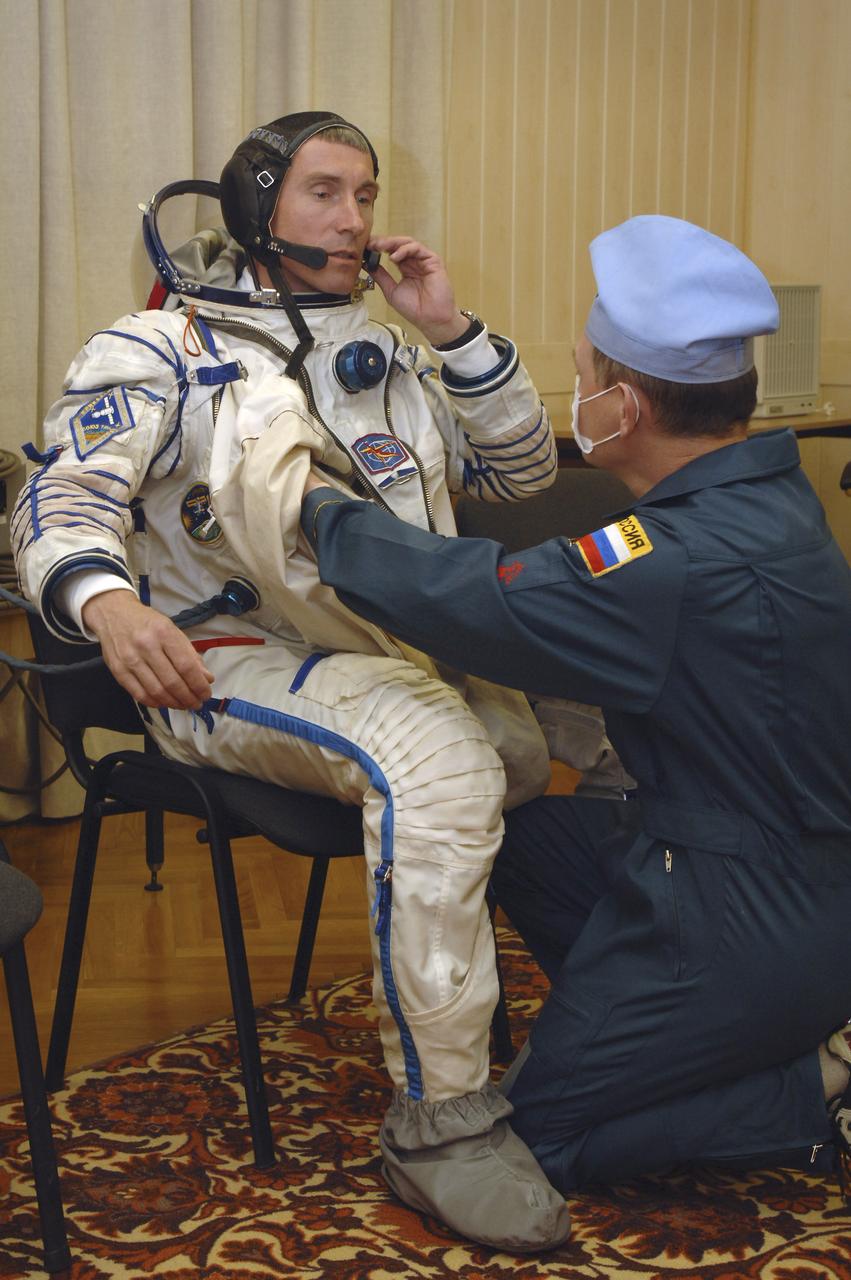 Expedition 11 Commander Sergei Krikalev, left, is outfitted in his Russian Sokol suit, Friday, April 15, 2005, in Baikonur, Kazakhstan. Krikalev, along with Flight Engineer and NASA Science Officer John Phillips and European Space Agency Astronaut Roberto Vittori, of Italy, were preparing for launch aboard the Soyuz TMA-6 spacecraft from the Baikonur Cosmodrome in Kazakhstan at daybreak on April 15 for a two-day trip to the International Space Station. Krikalev and Phillips will spend six months on the station, replacing Expedition 10 Commander Leroy Chiao and Flight Engineer Salizhan Sharipov, while Vittori will spend eight days on the Station under a commerical contract between ESA and the Russian Federal Space Agency, returning to Earth with Chiao and Sharipov on April 25. Photo Credit: (NASA/Bill Ingalls)