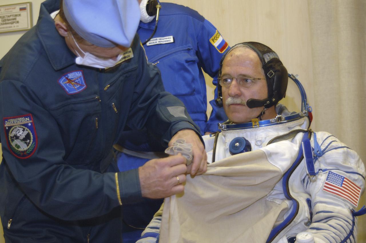 Technicians work on the Russian Sokol suit of Expedition 11 Flight Engineer and NASA Science Officer John Phillips, seated, prior to launch aboard the Soyuz TMA-6 spacecraft at the Baikonur Cosmodrome in Baikonur, Kazakhstan, Friday, April 15, 2005 for a two-day trip to the International Space Station. Photo Credit: (NASA/Bill Ingalls)
