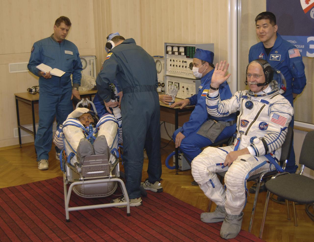 Expedition 11 Commander Sergei Krikalev, left, and Flight Engineer and NASA Science Officer John Phillips, seated right, along with NASA astronaut Dan Tani, standing, are seen, Friday, April 15, 2005, during preparations for launch aboard the Soyuz TMA-6 spacecraft from the Baikonur Cosmodrome in Kazakhstan for a two-day trip to the International Space Station. Photo Credit: (NASA/Bill Ingalls)