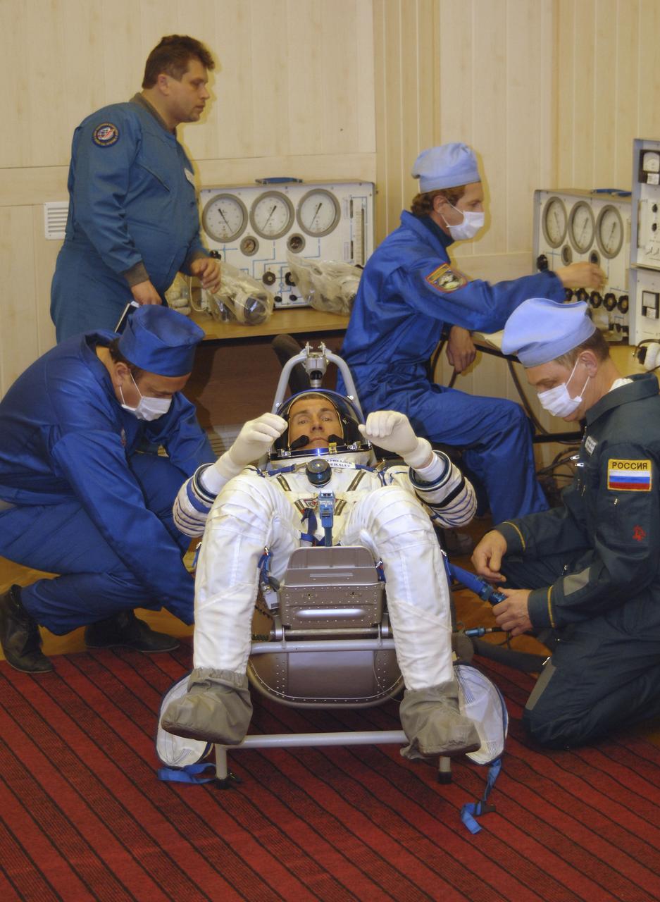 Technicians work on the Russian Sokol suit of Expedition 11 Commander Sergei Krikalev, seated, prior to launch aboard the Soyuz TMA-6 spacecraft at the Baikonur Cosmodrome in Baikonur, Kazakhstan, Friday, April 15, 2005 for a two-day trip to the International Space Station. Photo Credit: (NASA/Bill Ingalls)