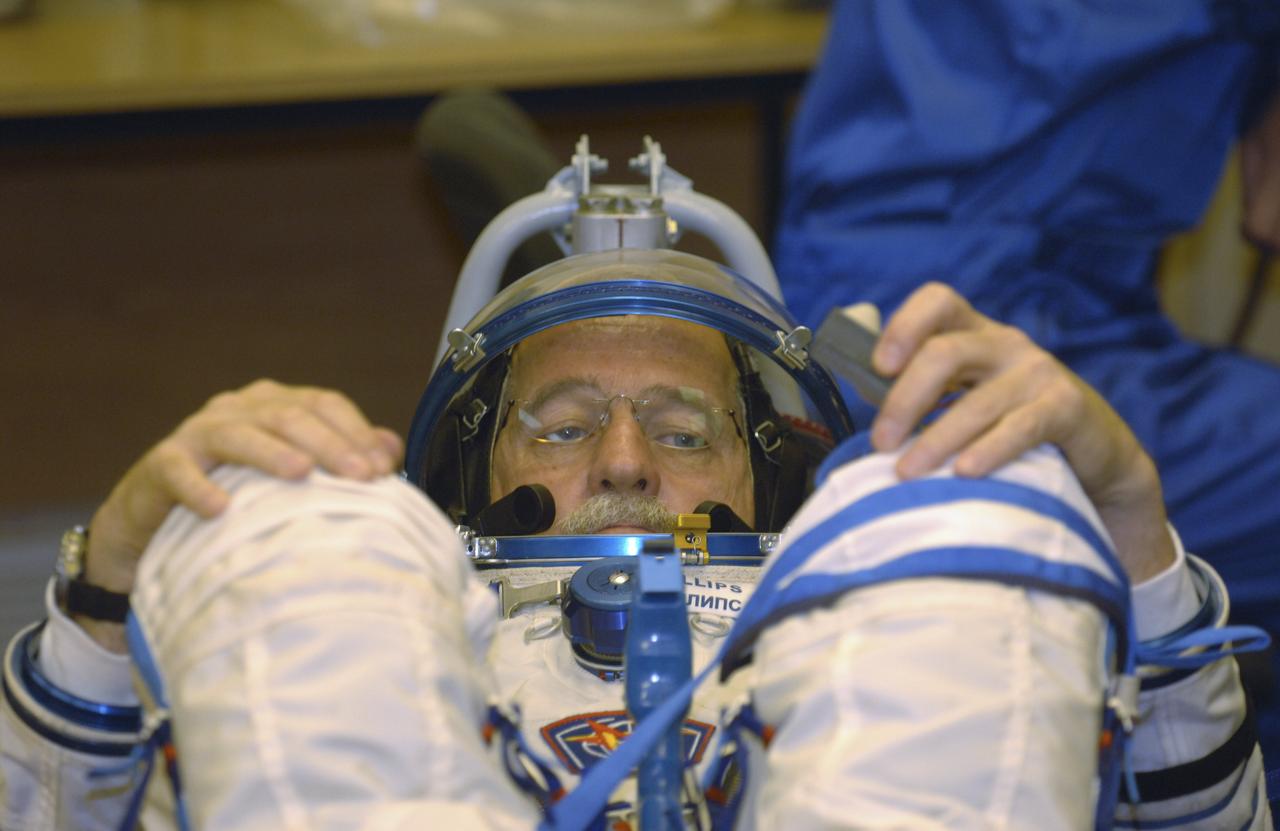 Technicians work on the Russian Sokol suit of Expedition 11 Flight Engineer and NASA Science Officer John Phillips prior to launch aboard the Soyuz TMA-6 spacecraft at the Baikonur Cosmodrome in Baikonur, Kazakhstan, Friday, April 15, 2005 for a two-day trip to the International Space Station. Photo Credit: (NASA/Bill Ingalls)