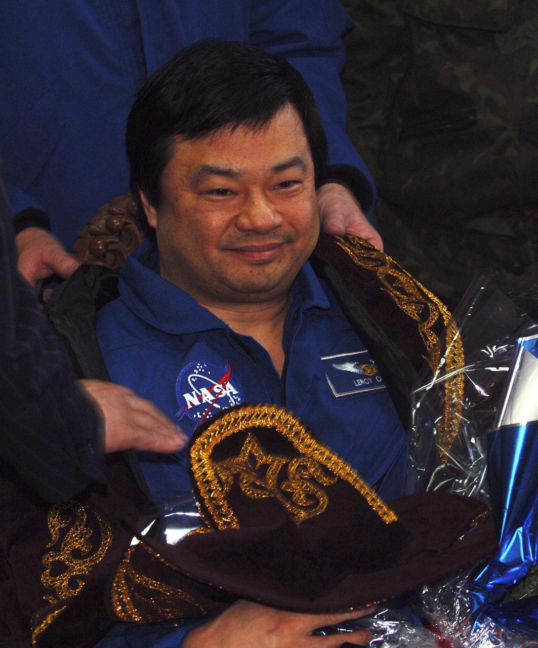 Expedition 10 Commander Leroy Chiao receives flowers upon arrival in Kustanay, Kazakhstan, Monday, April 25, 2005.  Chiao, Flight Engineer Salizhan Sharipov and European Space Agency astronaut Roberto Vittori brought their Soyuz TMA-5 capsule to a pre-dawn landing April 25 northeast of the town of Arkalyk to wrap up a six-month mission aboard the International Space Station for Chiao and Sharipov, and a ten-day mission for Vittori, who flew under a commercial contract between ESA and the Russian Federal Space Agency.  Photo Credit: (NASA/Bill Ingalls)