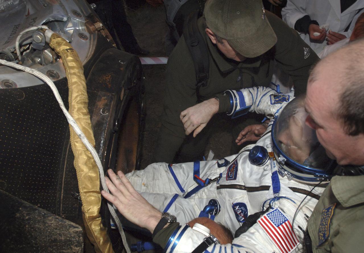 Expedition 11 astronaut John Phillips is helped out of the Soyuz capsule, Tuesday, Oct. 11, 2005, after landing near Arlalyk, Kazakhstan. Phillips and Expedition 11 cosmonaut Sergei Krikalev, landed after a six-month mission in orbit. Along with American businessman Greg Olsen, who visited the station for more than a week, Phillips and Krikalev returned to Earth aboard a Russian Soyuz spacecraft. Photo Credit: (NASA/Bill Ingalls)