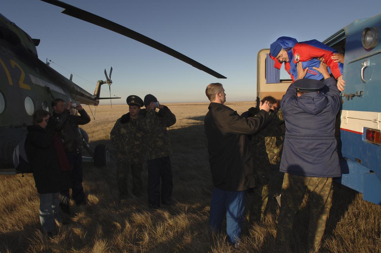 Expedition 11 astronaut John Phillips is helped out of a Russian Search and Rescue all terrain vehicle, Tuesday, Oct. 11, 2005, after landing near Arlalyk, Kazakhstan. Members of the 11th expedition to the international space station, astronaut John Phillips and cosmonaut Sergei Krikalev landed after a six-month mission in orbit. Along with American businessman Greg Olsen, who visited the station for more than a week, Phillips and Krikalev returned to Earth aboard a Russian Soyuz spacecraft. Photo Credit: (NASA/Bill Ingalls)