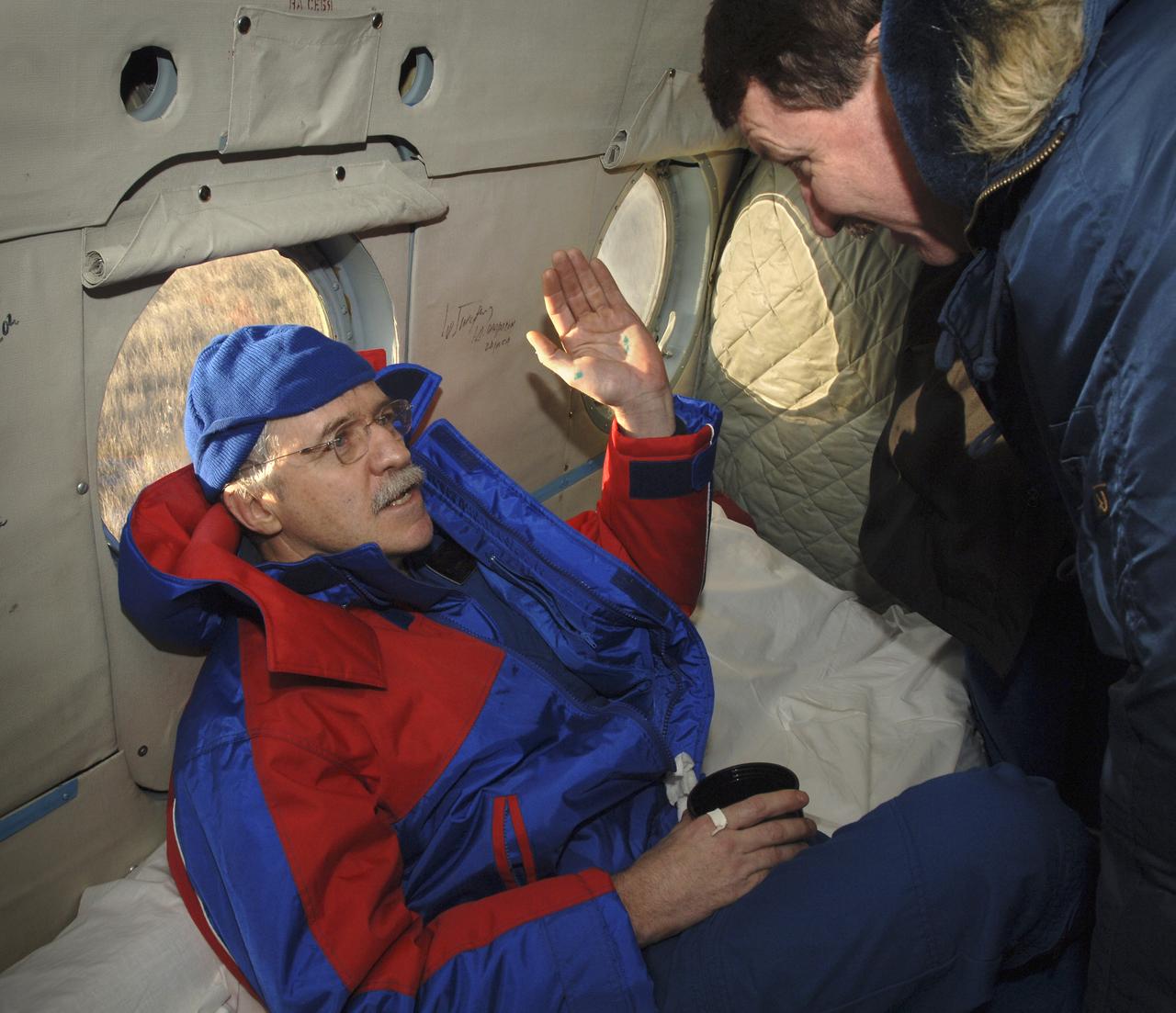 NASA astronaut John Phillips talks with astronaut Kent Rominger onboard a Russian Search and Rescue helicopter as they prepare to fly to Kustanay, Kazakhstan, following touchdown, Tuesday, Oct. 11, 2005, near Arlalyk, Kazakhstan. Members of the 11th expedition to the international space station, astronaut John Phillips and cosmonaut Sergei Krikalev, landed after a six-month mission in orbit. Along with American businessman Greg Olsen, who visited the station for more than a week, Phillips and Krikalev returned to Earth aboard a Russian Soyuz spacecraft. Photo Credit: (NASA/Bill Ingalls)