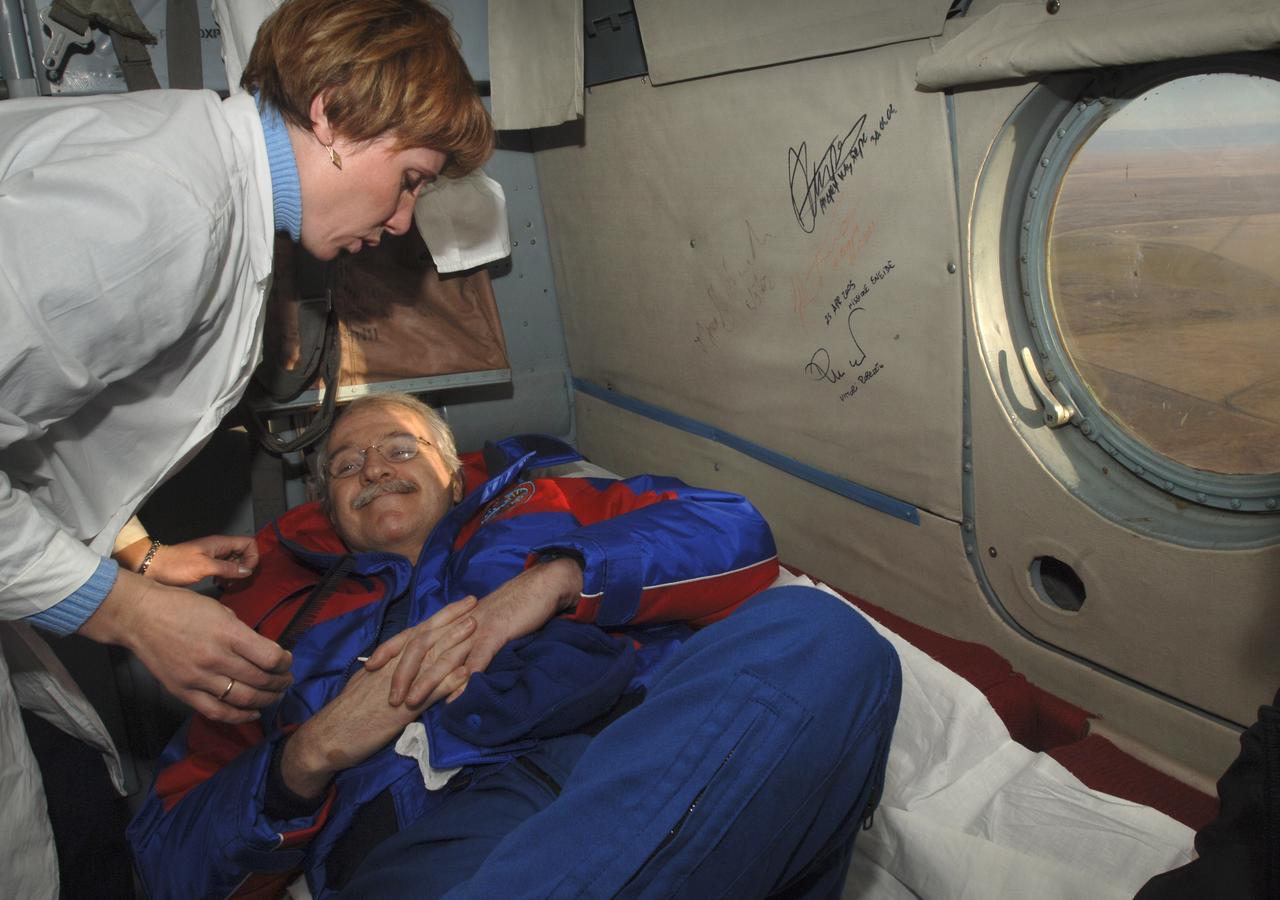 Astronaut John Phillips is attended to by a Russian nurse onboard the helicopter taking him from the Soyuz landing site near Arlalyk to Kustanay, Kazkahstan, Tuesday, Oct. 11, 2005. Members of the 11th expedition to the international space station, Phillips and cosmonaut Sergei Krikalev, landed near Arlalyk after a six-month mission in orbit. Along with American businessman Greg Olsen, who visited the station for more than a week, Phillips and Krikalev returned to Earth aboard a Russian Soyuz spacecraft. Photo Credit: (NASA/Bill Ingalls)