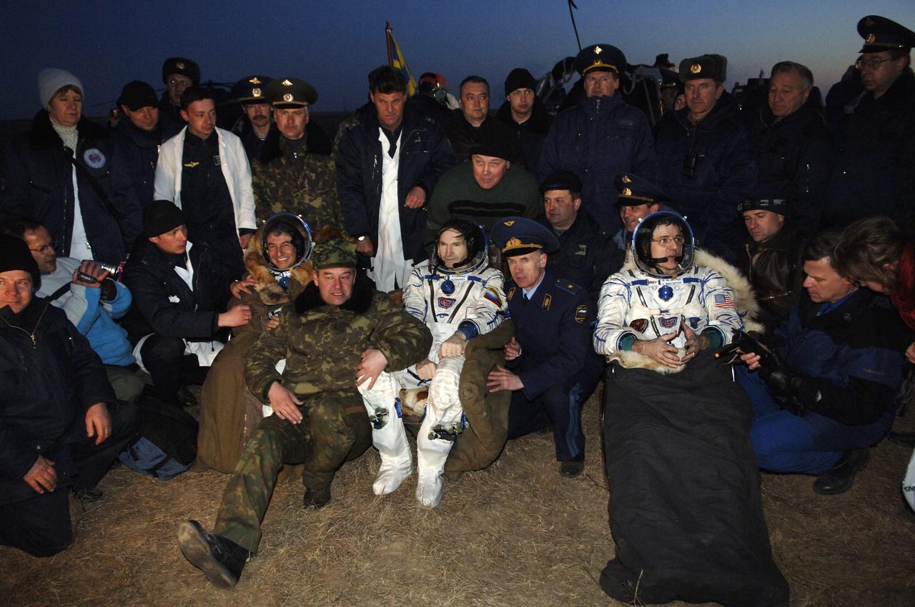 The two Expedition 12 crew members and a Brazilian astronaut are met by a couple of dozen greeters on hand at the landing site of the Soyuz TMA-7 spacecraft in the steppes of Kazakhstan on Sunday, April 9, 2006. Still wearing their spacesuits (in the foreground, left to right) are Marcos C. Pontes of Brazil, Valery I. Tokarev of Russia's Federal Space Agency and William S. McArthur Jr. Photo Credit: (NASA/Bill Ingalls)