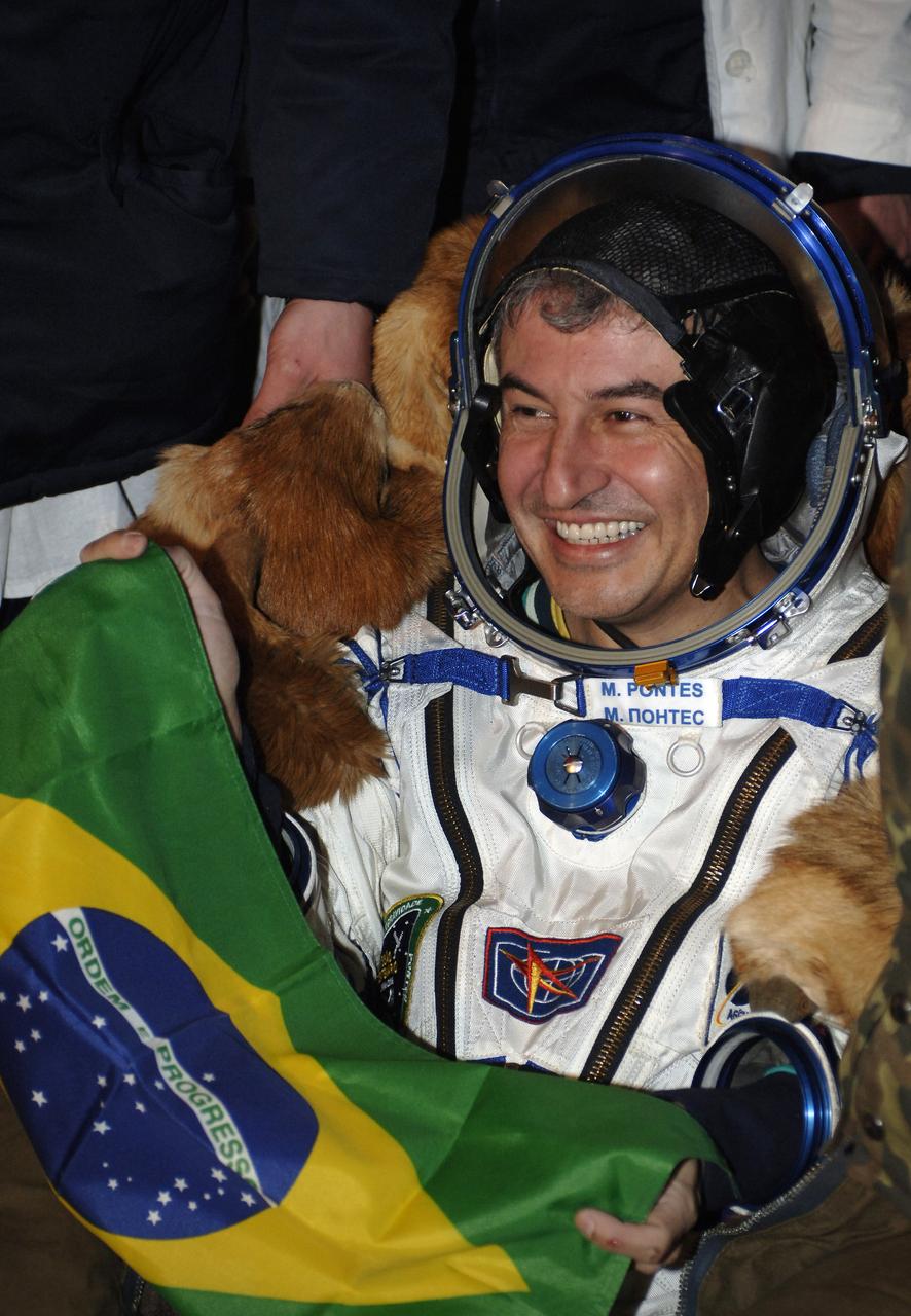 Brazil’s first astronaut in space, Marcos C. Pontes smiles as he exchanges greetings with some of the crowd on hand in the steppes of Kazakhstan to meet him and the two Expedition 12 crewmembers returning to Earth from the International Space Station in the Soyuz TMA-7 spacecraft on Saturday, April 9, 2006. The Soyuz TMA-7 spacecraft touched down at 7:48 p.m. EDT. Pontes spent a little over a week onboard the orbital outpost. He arrived at the station with Expedition 13 on Sunday, April 1, 2008. He represented the Brazil Space Agency. Photo Credit: (NASA/Bill Ingalls)
