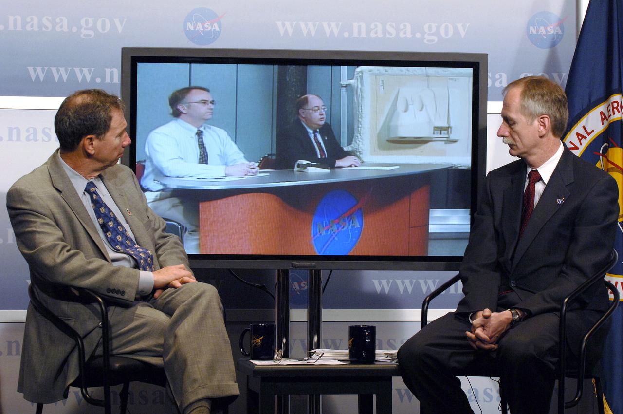NASA Administrator Michael Griffin, left, and Associate Administrator for Space Operations William Gerstenmaier, right, look on as Space Shuttle Program Manager Wayne Hale speaks from NASA's Marshall Space Flight Center during a media briefing about the space shuttle program and processing for the STS-121 mission, Friday, April 28, 2006, at NASA Headquarters in Washington. At left on screen is Ken Welzyn, External Tank Chief Engineer. Photo Credit (NASA/Bill Ingalls)