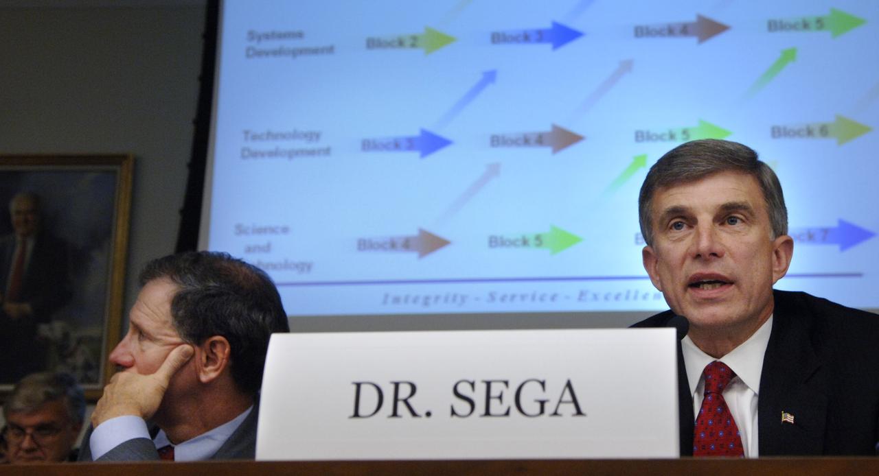 Under Secretary of the Air Force Dr. Ronald Sega, right, testifies before the House Committee on Science and Technology regarding the future of the National Polar-orbiting Operational Environmental Satellite System (NPOESS) and results of the Nunn-McCurdy review of NOAA’s weather satellite program as NASA Administrator Michael Griffin, left, looks at a television monitor, Thursday, June 8, 2006, at the Rayburn House Office Building in Washington. Photo Credit: (NASA/Bill Ingalls)
