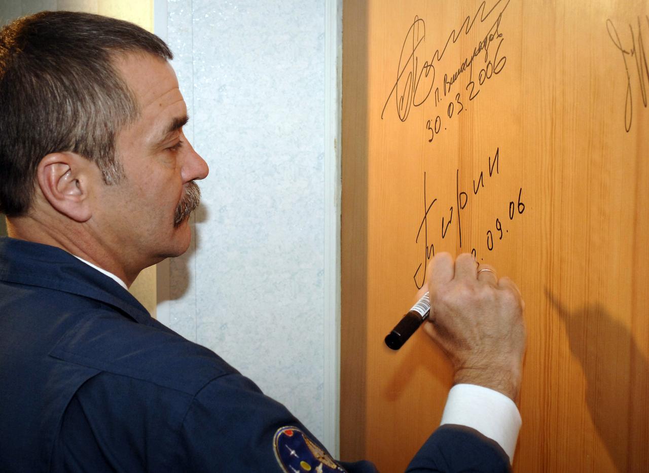 Soyuz Commander and Expedition 14 Flight Engineer Mikhail Tyurin signs the door of a hotel room at the Cosmonaut Hotel the morning of his launch onboard the Soyuz TMA-9 spacecraft, Monday, Sept. 18, 2006, in Baikonur, Kazakhstan. The Soyuz TMA-9 spacecraft launched from the Baikonur Cosmodrome carrying Expedition 14 Commander Michael Lopez-Alegria, Soyuz Commander and Expedition 14 Flight Engineer Mikhail Tyurin and American spaceflight participant Anousheh Ansari to the International Space Station. Anousheh Ansari will spend nine days on the station under a commercial agreement with the Russian Federal Space Agency. Photo Credit: (NASA/Bill Ingalls)