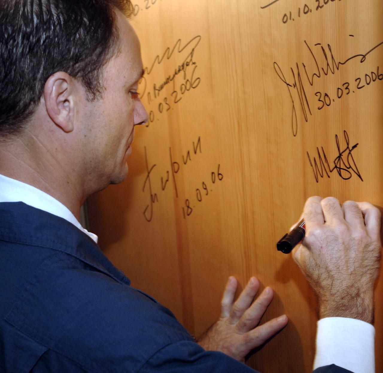 Expedition 14 Commander Michael Lopez-Alegria signs the door of a hotel room at the Cosmonaut Hotel the morning of his launch onboard the Soyuz TMA-9 spacecraft, Monday, Sept. 18, 2006, in Baikonur, Kazakhstan. The Soyuz TMA-9 spacecraft launched from the Baikonur Cosmodrome in carrying Expedition 14 Commander Michael Lopez-Alegria, Soyuz Commander and Expedition 14 Flight Engineer Mikhail Tyurin and American spaceflight participant Anousheh Ansari to the International Space Station. Anousheh Ansari will spend nine days on the station under a commercial agreement with the Russian Federal Space Agency. Photo Credit: (NASA/Bill Ingalls)