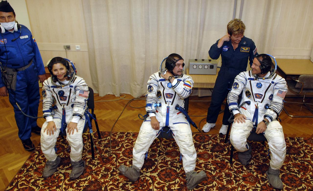 American spaceflight participant Anousheh Ansari, left, Soyuz Commander and Expedition 14 Flight Engineer Mikhail Tyurin and Expedition 14 Commander Michael Lopez-Alegria, right, await to go through pressure checks on their Russian Sokol suits at the Baikonur Cosmodrome prior to launch, Monday, Sept. 18, 2006, in Kazakhstan.  Their Soyuz TMA-9 spacecraft launched from the Baikonur Cosmodrome at 10:09 a.m. local time.  Ms. Ansari, will spend nine days on the International Space Station under a commercial agreement with the Russian Federal Space Agency.  Photo Credit: (NASA/Bill Ingalls)