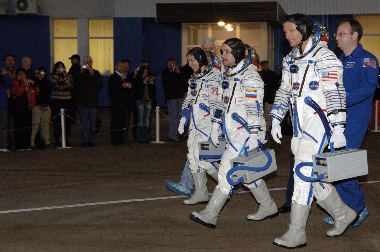 American spaceflight participant Anousheh Ansari, third from right, Soyuz Commander and Expedition 14 Flight Engineer Mikhail Tyurin and Expedition 14 Commander Michael Lopez-Alegria, right, walk out of building 254 of the Baikonur Cosmodrome, Monday, Sept. 18, 2006, in Baikonur, Kazakhstan. Their Soyuz TMA-9 spacecraft launched from the Baikonur Cosmodrome at 10:09 a.m. local time.  Anousheh Ansari, will spend nine days on the International Space Station under a commercial agreement with the Russian Federal Space Agency.  Photo Credit: (NASA/Bill Ingalls)