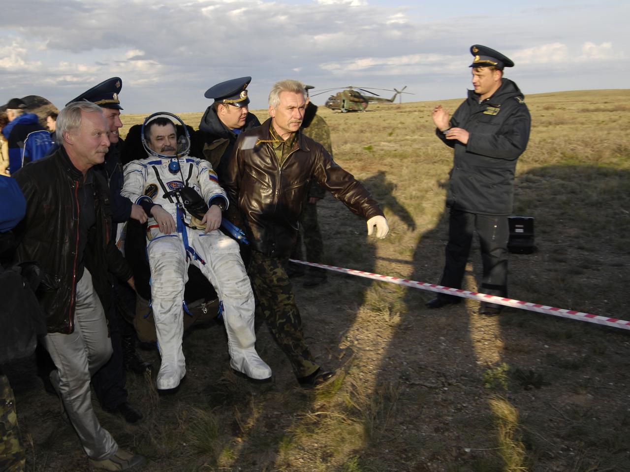 Expedition 14 Flight Engineer Mikhail Tyurin is taken in his chair to the medical tent near the Soyuz TMA-9 spacecraft where the recovery officials conduct post-landing medical checks, Friday, April 21, 2007 in Kazakhstan. Expedition 14 Commander Michael Lopez-Alegria, Flight Engineer Mikhail Tyurin and American spaceflight participant Charles Simonyi landed in their Soyuz TMA-9 spacecraft southwest of Karaganda, Kazakhstan at approximately 6:30 p.m. local time. Photo Credit: (NASA/Bill Ingalls)