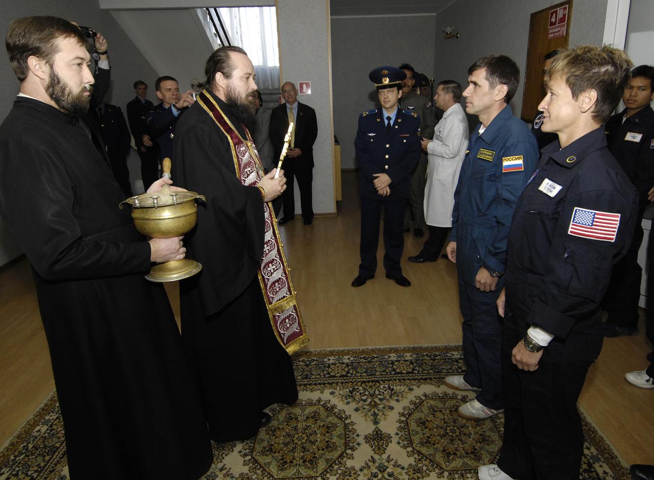 Expedition 16 Commander Peggy Whitson, right, Flight Engineer and Soyuz Commander Yuri Malenchenko participate in the traditional blessing prior to joining Malaysian spaceflight participant Sheikh Muszaphar Shukor for the bus ride to building 254 at the Baikonur Cosmodrome where the crew don their spacesuits, Wednesday, Oct. 10, 2007, in Baikonur. The crew is set to launch at sunset in their Soyuz TMA-11 spacecraft bound for a docking to the International Space Station on October 12. Whitson and Malenchenko will spend six months on the station, while Shukor will return to Earth October 21 with two of the Expedition 15 crewmembers currently on the complex. Photo Credit: (NASA/Bill Ingalls)