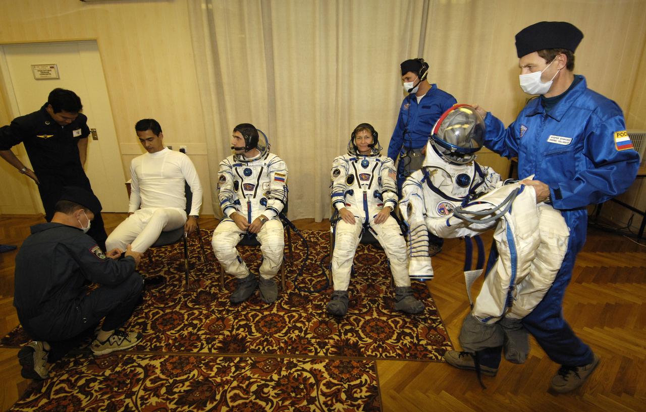 Malaysian spaceflight participant Sheikh Muszaphar Shukor, left sitting, Flight Engineer and Soyuz Commander Yuri Malenchenko and Expedition 16 Commander Peggy Whitson, right sitting, don their flight suits prior to launch at the Baikonur Cosmodrome in Kazakhstan, Wednesday, Oct. 10, 2007. The three launched at sunset in their Soyuz TMA-11 spacecraft bound for a docking to the International Space Station on Oct. 12. Whitson and Malenchenko will spend six months on the station, while Shukor will return to Earth Oct. 21 with two of the Expedition 15 crewmembers currently on the complex. Photo Credit: "NASA/Bill Ingalls)