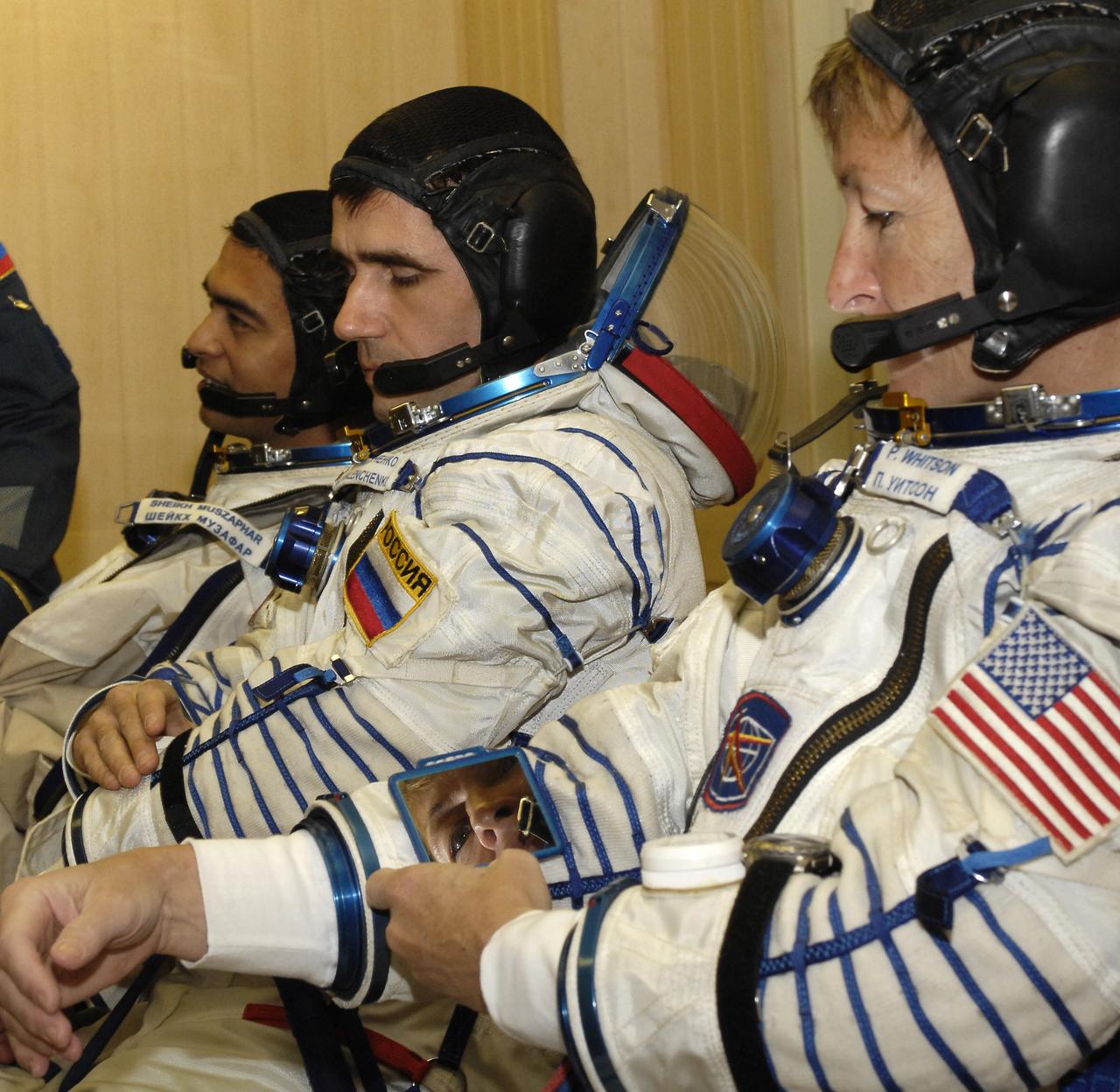 Expedition 16 Commander Peggy Whitson, right, adjusts the mirror on her Russian sokol suit, Wednesday, Oct. 10, 2007, in Baikonur, Kazakhstan. Flight Engineer and Soyuz Commander Yuri Malenchenko, center, and Malaysian spaceflight participant Sheikh Muszaphar Shukor are seen next to her. The three launched at sunset Oct. 10 in their Soyuz TMA-11 spacecraft bound for a docking to the International Space Station on Oct. 12. Whitson and Malenchenko will spend six months on the station, while Shukor will return to Earth Oct. 21 with two of the Expedition 15 crewmembers currently on the complex. Photo Credit: (NASA/Bill Ingalls)