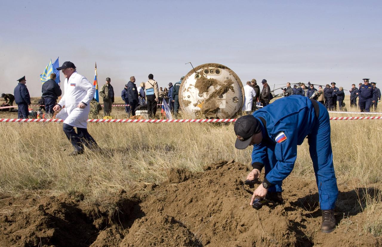 A Russian ground crew member examines the over turned soil near the Soyuz TMA-11 spacecraft after it landed carrying Expedition 16 Commander Peggy Whitson, Flight Engineer and Soyuz Commander Yuri Malenchenko and South Korean spaceflight participant So-yeon Yi, Friday, April 19, 2008, in central Kazakhstan to complete 192 days in space for Whitson and Malenchenko and 11 days in orbit for Yi. Photo Credit: (NASA/Reuters/Pool)