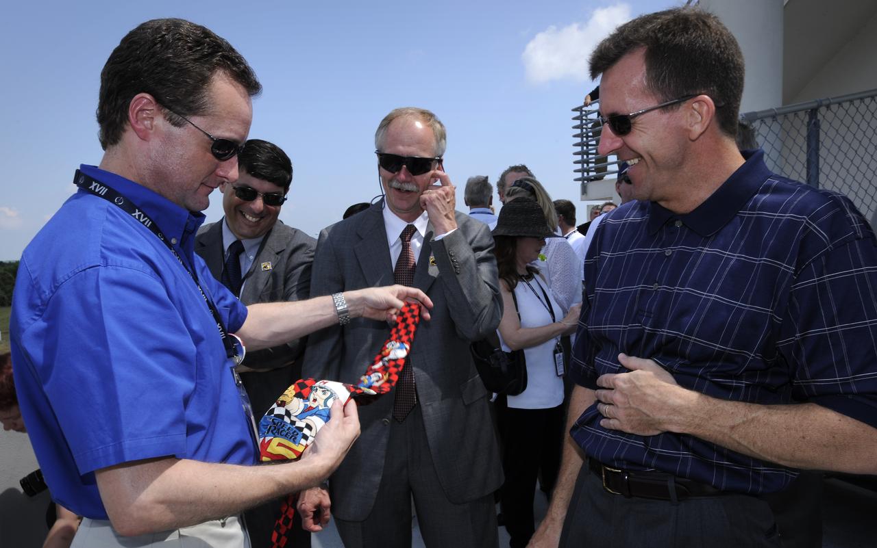 NASA Lead Shuttle Flight Director for STS-124 Matt Abbott, left, shows his lucky launch and landing tie to NASA Associate Administrator Chris Scolese, 2nd from left, NASA Associate Administrator for Space Operations Bill Gerstenmaier, 3rd from left, and NASA Deputy Shuttle Program Manager LeRoy Cain shortly after the space shuttle Discovery touched down at 11:15 a.m., Saturday, June 14, 2008, at the Kennedy Space Center in Cape Canaveral, Florida.  During the 14-day STS-124 mission Discovery's crew installed the Japan Aerospace Exploration Agency's large Kibo laboratory and its remote manipulator system leaving a larger space station and one with increased science capabilities. Photo Credit: (NASA/Bill Ingalls)