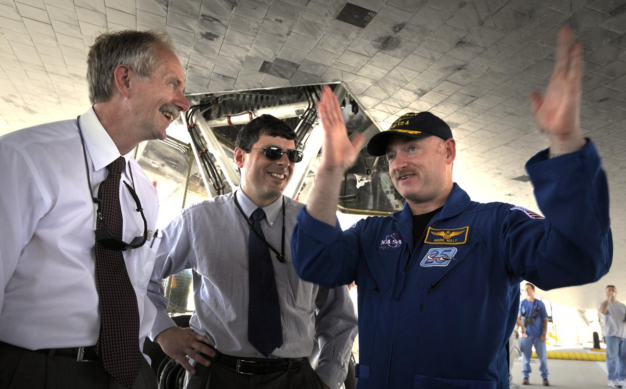 NASA Astronaut and STS-124 commander Mark E. Kelly, right, talks with NASA Associate Administrator Chris Scolese, center, and NASA Associate Administrator for Space Operations Bill Gerstenmaier underneath the space shuttle Discovery shortly after landing on runway 15 of the NASA Kennedy Space Center, Shuttle Landing Facility at 11:15 a.m., Saturday, June 14, 2008 in Cape Canaveral, Florida.  Onboard Discovery were NASA astronauts Mark Kelly, commander; Ken Ham, pilot; Mike Fossum, Ron Garan, Karen Nyberg, Garrett Reisman and Japan Aerospace Exploration Agency astronaut Akihiko Hoshide, all mission specialists. During the STS-124 mission, Discovery's crew installed the Japan Aerospace Exploration Agency's large Kibo laboratory and its remote manipulator system leaving a larger space station and one with increased science capabilities. Photo Credit: (NASA/Bill Ingalls)