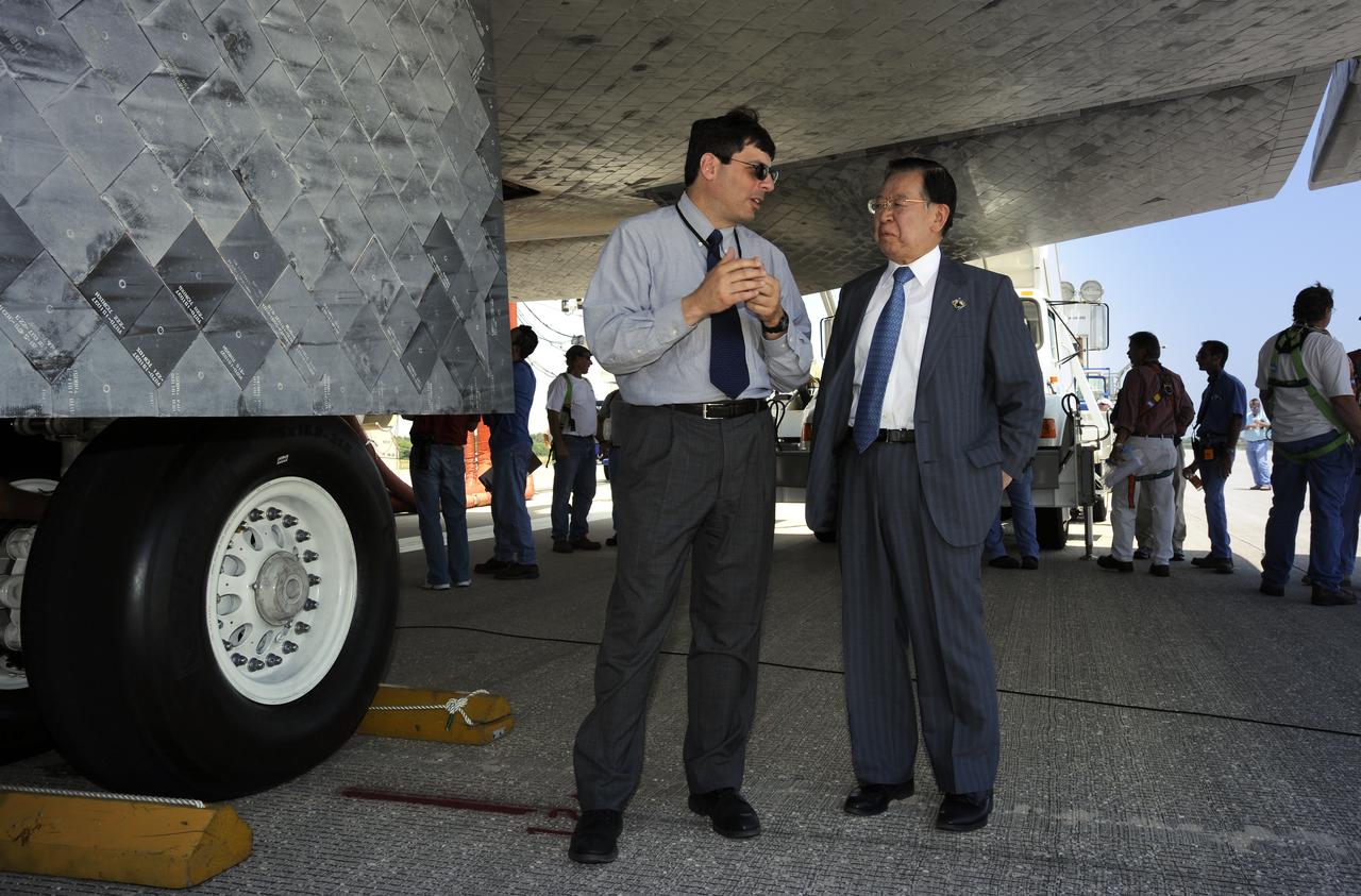 NASA Associate Administrator Chris Scolese, left and the Vice President of the Japan Aerospace Exploration Agency (JAXA) Mr. Kaoru Mamiya talk underneath the wing of the space shuttle Discovery shortly after Discovery touched down at 11:15 a.m., Saturday, June 14, 2008, at the Kennedy Space Center in Cape Canaveral, Florida.  During the 14-day STS-124 mission Discovery's crew installed the Japan Aerospace Exploration Agency's large Kibo laboratory and its remote manipulator system leaving a larger space station and one with increased science capabilities. Discovery also brought home NASA astronaut Garrett Reisman after his 3 month mission onboard the International Space Station. Photo Credit: (NASA/Bill Ingalls)