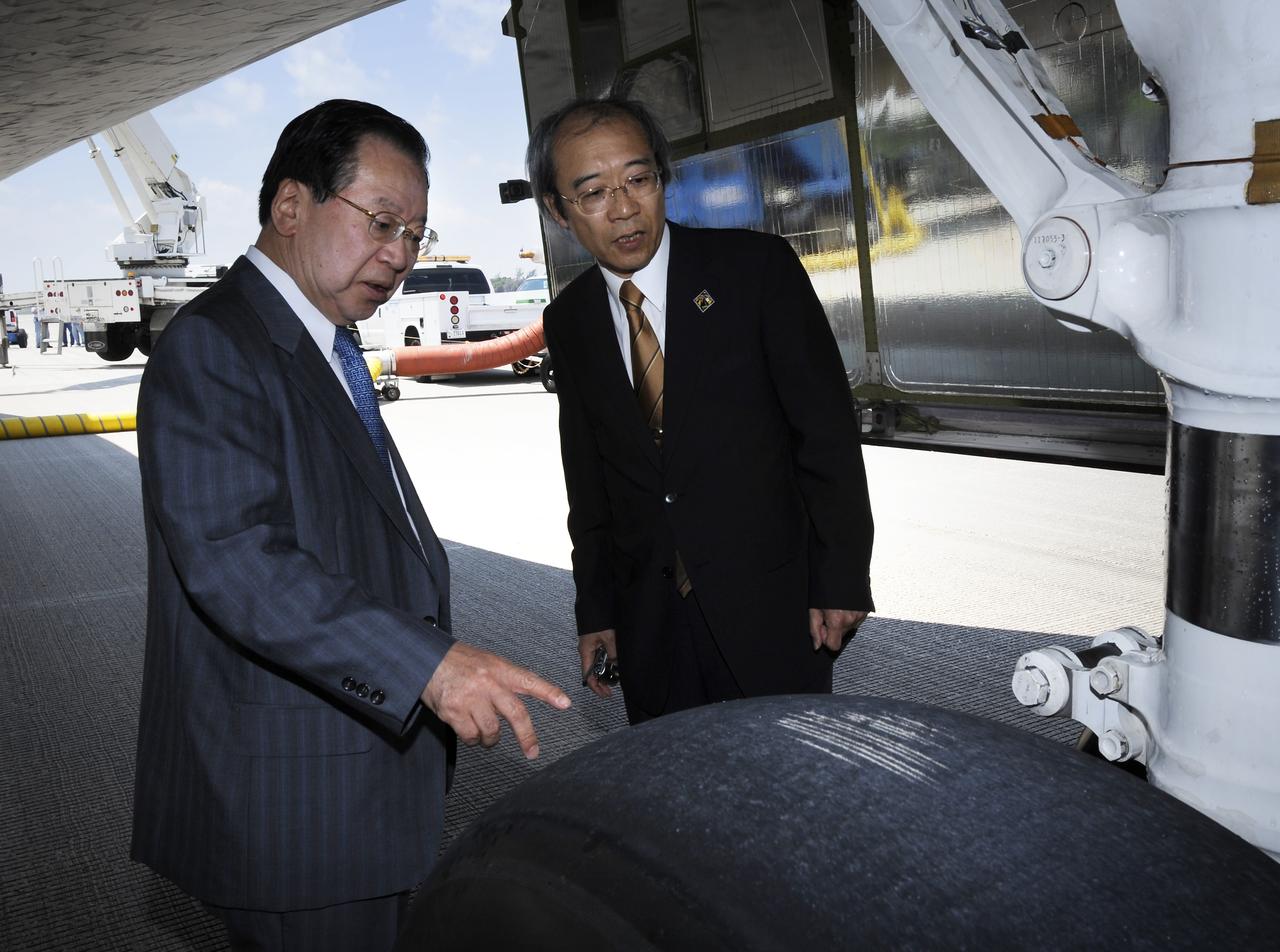 Vice President of the Japan Aerospace Exploration Agency (JAXA) Mr. Kaoru Mamiya, left, and Mr. Yuichi Yamaura of JAXA look at one of the space shuttle Discovery tires shortly after Discovery touched down at 11:15 a.m., Saturday, June 14, 2008, at the Kennedy Space Center in Cape Canaveral, Florida.  During the 14-day STS-124 mission Discovery's crew installed the Japan Aerospace Exploration Agency's large Kibo laboratory and its remote manipulator system leaving a larger space station and one with increased science capabilities. Discovery also brought home NASA astronaut Garrett Reisman after his 3 month mission onboard the International Space Station. Photo Credit: (NASA/Bill Ingalls)