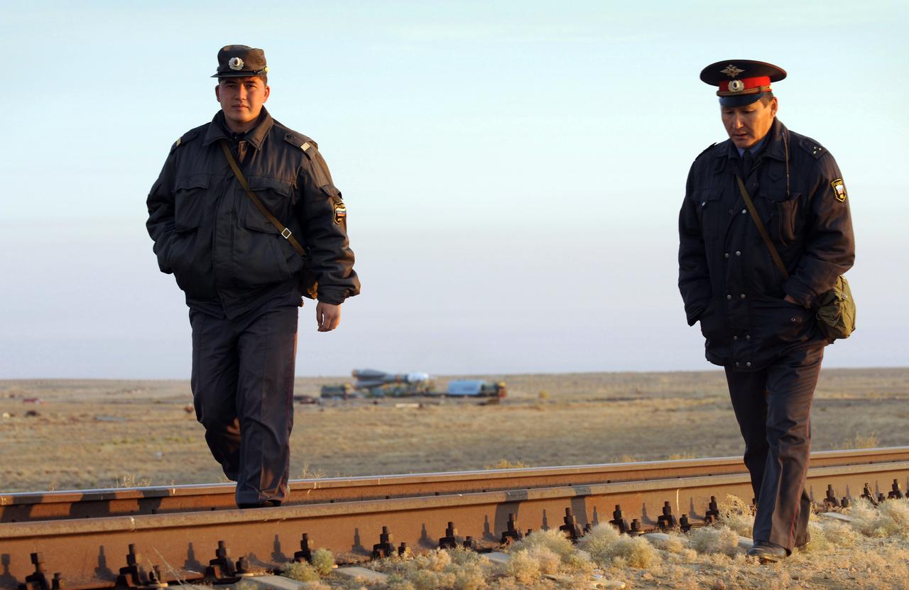 Russian security personnel walk the railroad line ahead of the Soyuz TMA-13 spacecraft as it is transported by railcar to its launch pad at the Baikonur Cosmodrome in Kazakhstan, Friday, Oct. 10, 2008.  The Soyuz is scheduled to launch to the International Space Station Oct. 12 with Expedition 18 Commander Michael Fincke, Flight Engineer Yuri V. Lonchakov and American spaceflight participant Richard Garriott.  The three crew members will dock their Soyuz to the International Space Station on Oct. 14. Fincke and Lonchakov will spend six months on the station, while Garriott will return to Earth Oct. 24 with two of the Expedition 17 crew members currently on the International Space Station.  Photo Credit: (NASA/Bill Ingalls)