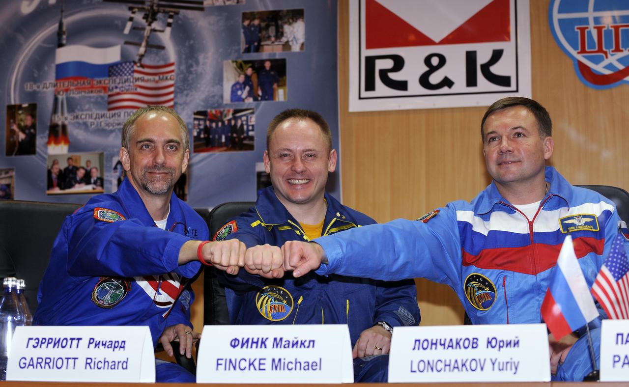 Expedition 18 Flight Engineer Yuri V. Lonchakov, right, Expedition 18 Commander Michael Fincke and American spaceflight participant Richard Garriott, left, pose for photographs after a press conference held at the Cosmonaut Hotel, Saturday, Oct. 11, 2008, in Baikonur, Kazakhstan. The Expedition 18 crew will launch on the Soyuz TMA-13 spacecraft on Oct. 12 and dock with the International Space Station on Oct. 14. Fincke and Lonchakov will spend six months on the station, while Garriott will return to Earth Oct. 24 with two of the Expedition 17 crew members currently on the International Space Station. Photo Credit: (NASA/Bill Ingalls)