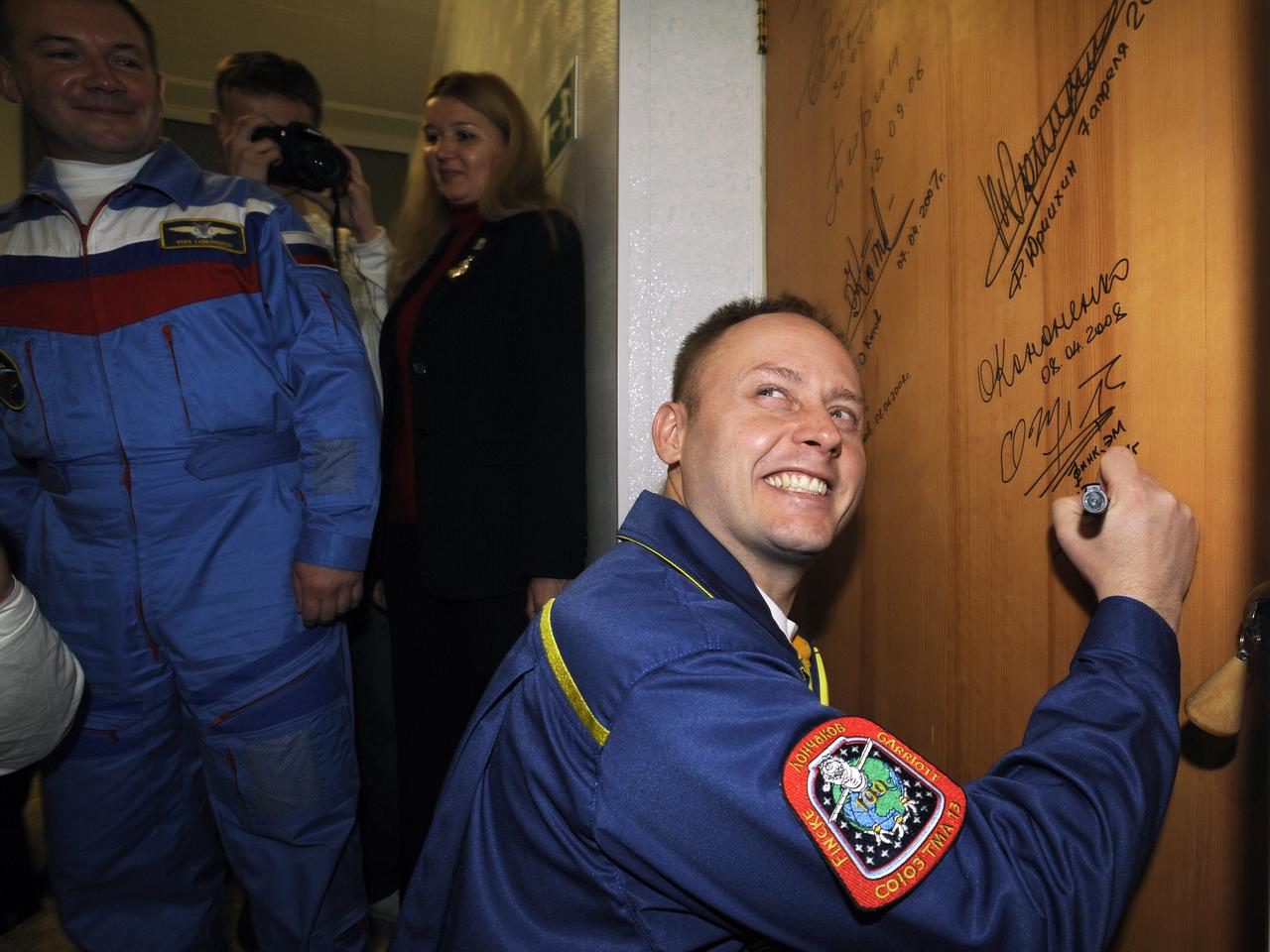 Expedition 18 Commander Michael Fincke signs the door of a hotel room at the Cosmonaut Hotel prior to departing for the launch aboard a Soyuz TMA-13 spacecraft, Sunday, Oct. 12, 2008, in Baikonur, Kazakhstan. The Soyuz TMA-13 spacecraft launched from the Baikonur Cosmodrome in Kazakhstan carrying Expedition 18 Commander Michael Fincke, Flight Engineer Yuri V. Lonchakov and American spaceflight participant Richard Garriott. Photo Credit: (NASA/Bill Ingalls)