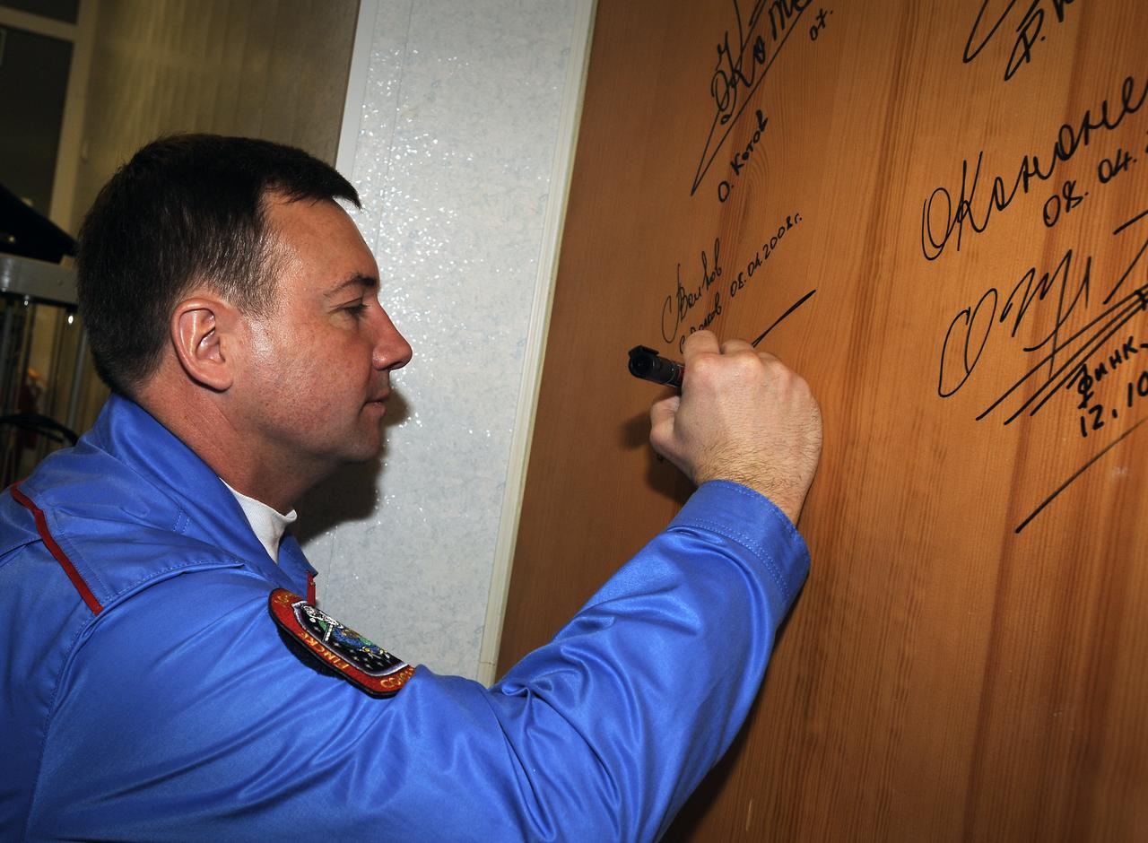 Expedition 18 Flight Engineer Yuri V. Lonchakov signs the door of a hotel room at the Cosmonaut Hotel prior to departing for the launch aboard a Soyuz TMA-13 spacecraft,   Sunday, Oct. 12, 2008, in Baikonur, Kazakhstan.  The Soyuz TMA-13 spacecraft launched from the Baikonur Cosmodrome in Kazakhstan carrying Expedition 18 Commander Michael Fincke, Flight Engineer Yuri V. Lonchakov and American spaceflight participant Richard Garriott.  Photo Credit: (NASA/Bill Ingalls)