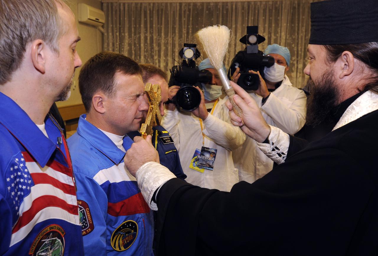 American spaceflight participant Richard Garriott, left, Expedition 18 Flight Engineer Yuri V. Lonchakov and Expedition 18 Commander Michael Fincke, right, participate in the traditional blessing prior to the bus ride to building 254 where the crew don their spacesuits, Sunday, Oct. 12, 2008, in Baikonur, Kazakhstan. The Soyuz TMA-13 spacecraft launched from the Baikonur Cosmodrome in Kazakhstan carrying Fincke, Lonchakov and Garriott. Photo Credit: (NASA/Bill Ingalls)