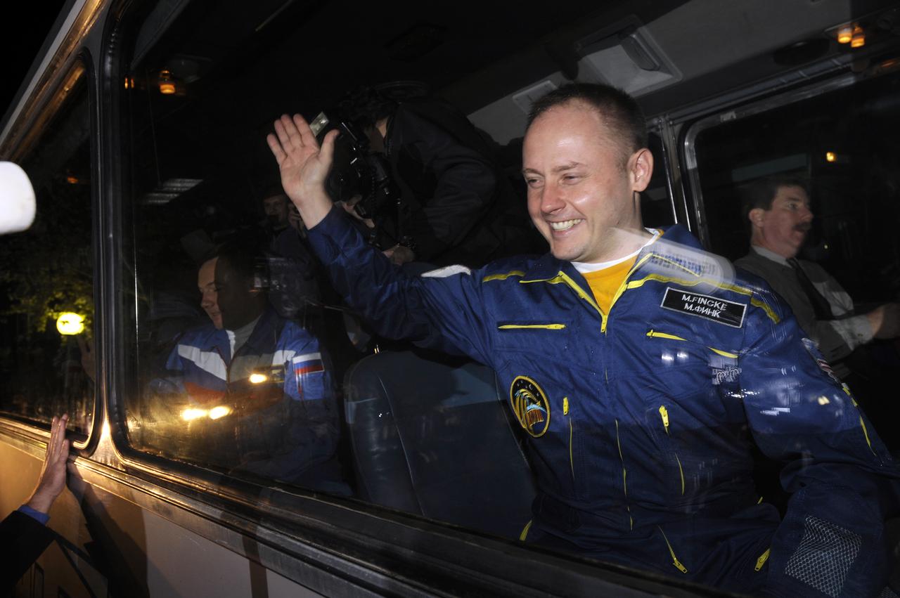 Expedition 18 Commander Michael Fincke waves farewell from the crew bus as he and Flight Engineer Yuri V. Lonchakov and American spaceflight participant Richard Garriott depart the Cosmonaut Hotel to building 254 were they will don their flight suits prior to their launch, Sunday, Oct. 12, 2008, from the Baikonur Cosmodrome in Kazakhstan. The three crew members are scheduled to dock with the International Space Station on Oct. 14. Fincke and Lonchakov will spend six months on the station, while Garriott will return to Earth Oct. 24 with two of the Expedition 17 crew members currently on the International Space Station. Photo Credit: (NASA/Bill Ingalls)