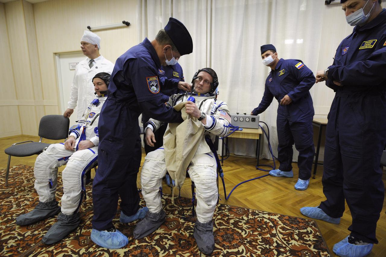 Expedition 18 Flight Engineer Yuri V. Lonchakov, left, and Expedition 18 Commander Michael Fincke don their Russian Sokol suits hours before they and American spaceflight participant Richard Garriott launch in the Soyuz TMA-13 spacecraft, Sunday, Oct. 12, 2008 from the Baikonur Cosmodrome in Kazakhstan. The three crew members are scheduled to dock with the International Space Station on Oct. 14. Fincke and Lonchakov will spend six months on the station, while Garriott will return to Earth Oct. 24 with two of the Expedition 17 crew members currently on the International Space Station. Photo Credit: (NASA/Bill Ingalls)