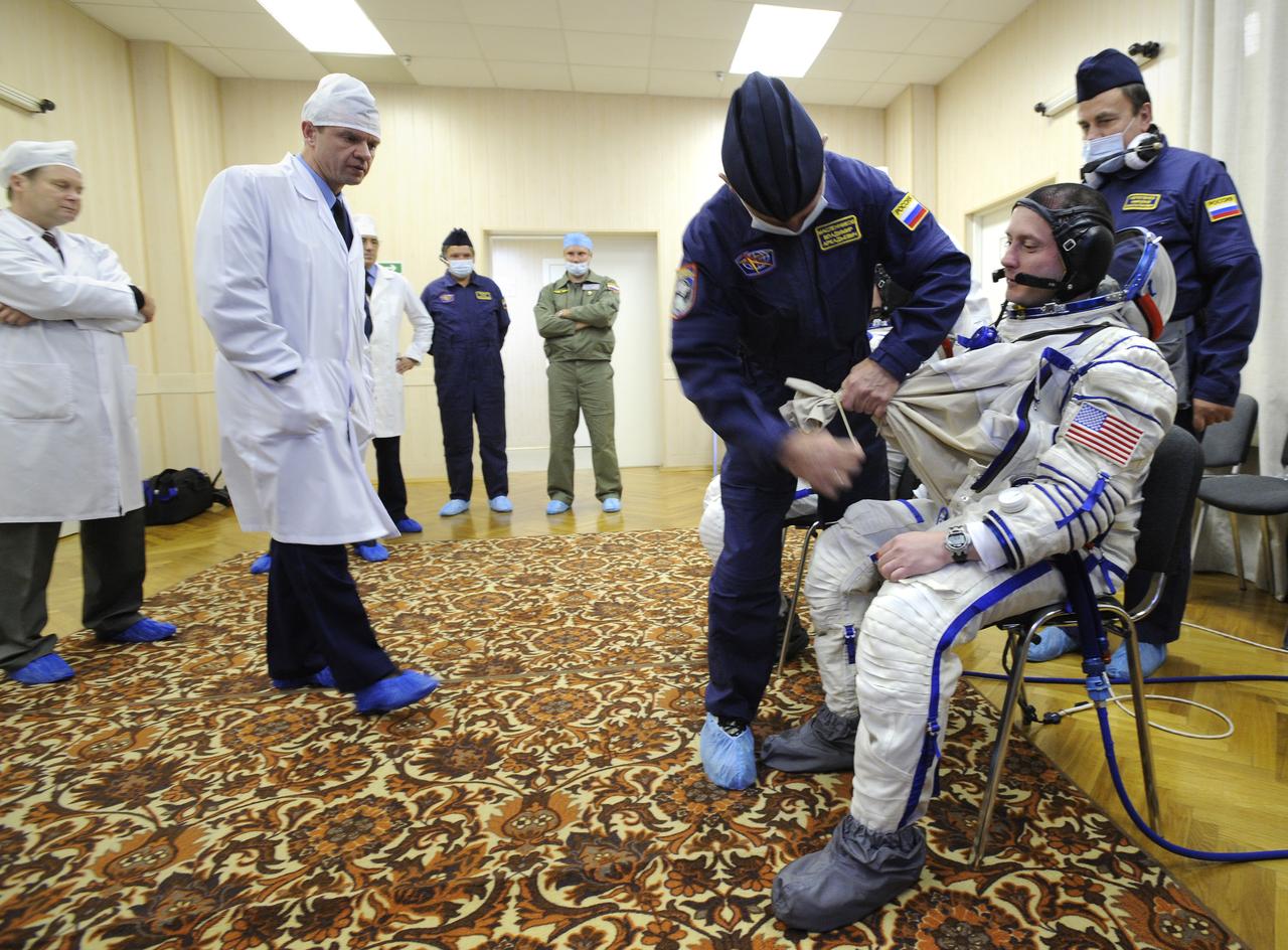 Expedition 18 Commander Michael Fincke dons his Russian Sokol suit hours before he and Expedition 18 Flight Engineer Yuri V. Lonchakov and American spaceflight participant Richard Garriott launch in the Soyuz TMA-13 spacecraft, Sunday, Oct. 12, 2008 from the Baikonur Cosmodrome in Kazakhstan. The three crew members are scheduled to dock with the International Space Station on Oct. 14. Fincke and Lonchakov will spend six months on the station, while Garriott will return to Earth Oct. 24 with two of the Expedition 17 crew members currently on the International Space Station. Photo Credit: (NASA/Bill Ingalls)