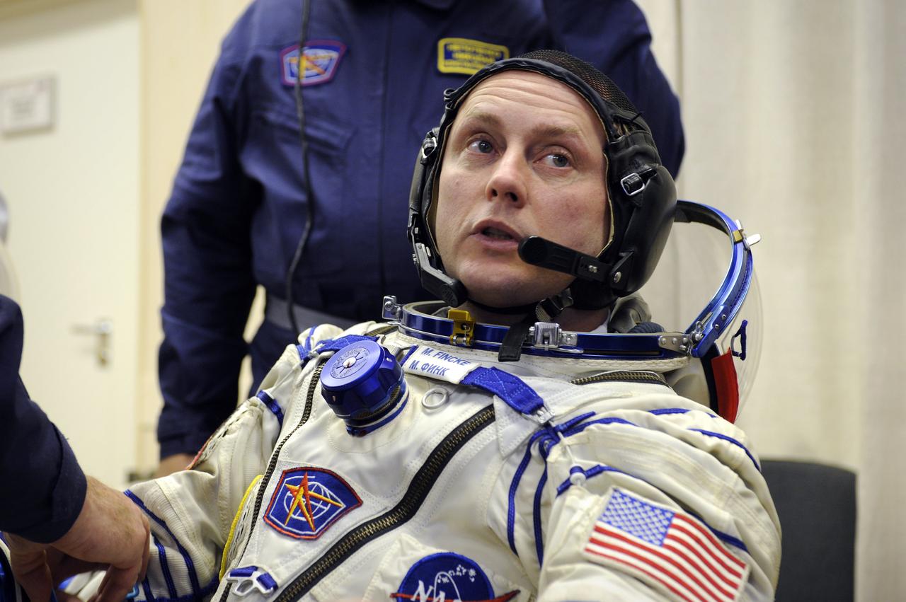 Expedition 18 Commander Michael Fincke dons his Russian Sokol suit hours before he and Expedition 18 Flight Engineer Yuri V. Lonchakov and American spaceflight participant Richard Garriott launch in the Soyuz TMA-13 spacecraft, Sunday, Oct. 12, 2008 from the Baikonur Cosmodrome in Kazakhstan. The three crew members are scheduled to dock with the International Space Station on Oct. 14. Fincke and Lonchakov will spend six months on the station, while Garriott will return to Earth Oct. 24 with two of the Expedition 17 crew members currently on the International Space Station. Photo Credit: (NASA/Bill Ingalls)