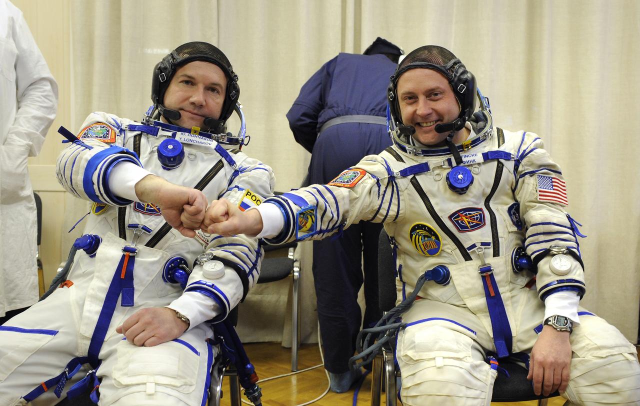 Expedition 18 Flight Engineer Yuri V. Lonchakov, left, and Expedition 18 Commander Michael Fincke pose for a photograph after they don their Russian Sokol suits prior to the launch in the Soyuz TMA-13 spacecraft, Sunday, Oct. 12, 2008 from the Baikonur Cosmodrome in Kazakhstan. The crew members are scheduled to dock with the International Space Station on Oct. 14. Fincke and Lonchakov will spend six months on the station, while American spaceflight participant Richard Garriott will return to Earth Oct. 24 with two of the Expedition 17 crew members currently on the International Space Station. Photo Credit: (NASA/Bill Ingalls)