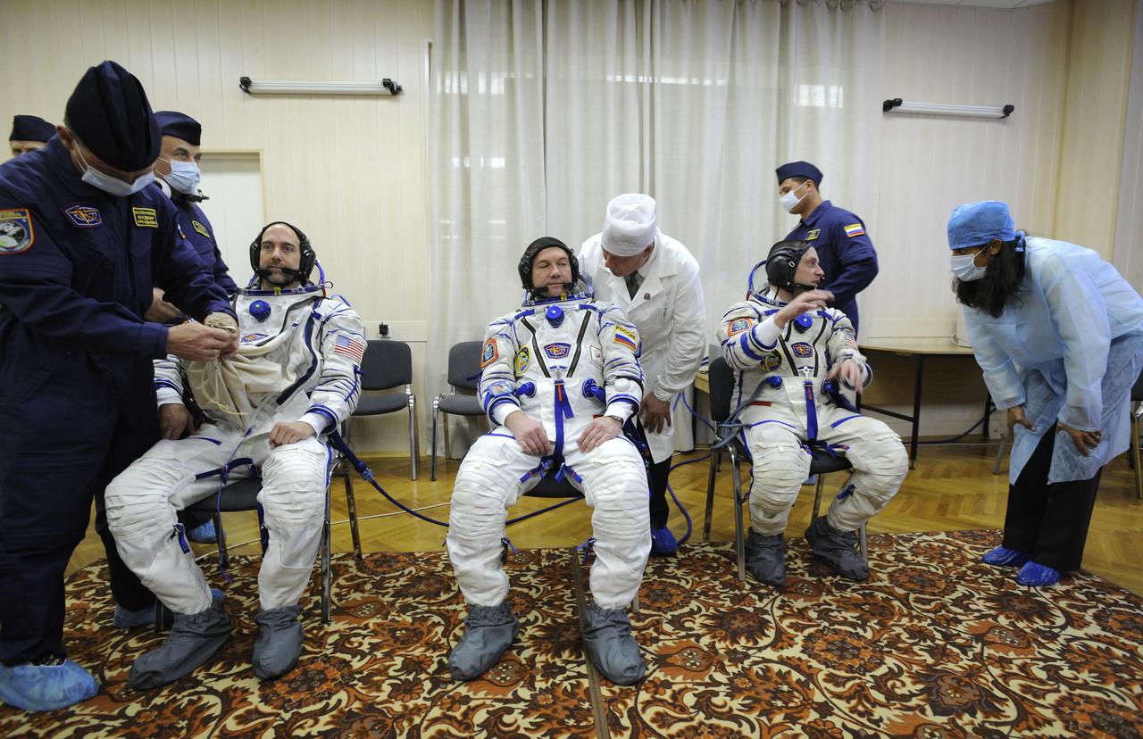 American spaceflight participant Richard Garriott, left, Expedition 18 Flight Engineer Yuri V. Lonchakov and Commander Michael Fincke, right, don their Russian Sokol suits hours before the launch in the Soyuz TMA-13 spacecraft, Sunday, Oct. 12, 2008 from the Baikonur Cosmodrome in Kazakhstan. The three crew members are scheduled to dock with the International Space Station on Oct. 14. Fincke and Lonchakov will spend six months on the station, while Garriott will return to Earth Oct. 24 with two of the Expedition 17 crew members currently on the International Space Station. Photo Credit: (NASA/Bill Ingalls)