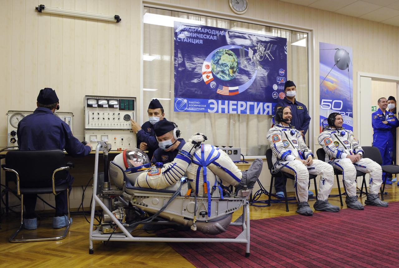Expedition 18 Commander Michael Fincke, foreground, has his Russian Sokol suit pressure checked prior to launching in the Soyuz TMA-13 spacecraft with American spaceflight participant Richard Garriott and Expedition 18 Flight Engineer Yuri V. Lonchakov, right, Sunday, Oct. 12, 2008 from the Baikonur Cosmodrome in Kazakhstan. The three crew members are scheduled to dock with the International Space Station on Oct. 14. Fincke and Lonchakov will spend six months on the station, while Garriott will return to Earth Oct. 24 with two of the Expedition 17 crew members currently on the International Space Station. Photo Credit: (NASA/Bill Ingalls)