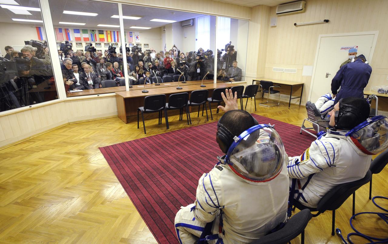 Expedition 18 Commander Michael Fincke waves hello to his family as he and Expedition 18 Flight Engineer Yuri V. Lonchakov and American spaceflight participant Richard Garriott have their Russian Sokol suits pressure checked prior to launching in the Soyuz TMA-13 spacecraft, Sunday, Oct. 12, 2008 from the Baikonur Cosmodrome in Kazakhstan. The three crew members are scheduled to dock with the International Space Station on Oct. 14. Fincke and Lonchakov will spend six months on the station, while Garriott will return to Earth Oct. 24 with two of the Expedition 17 crew members currently on the International Space Station. Photo Credit: (NASA/Bill Ingalls)